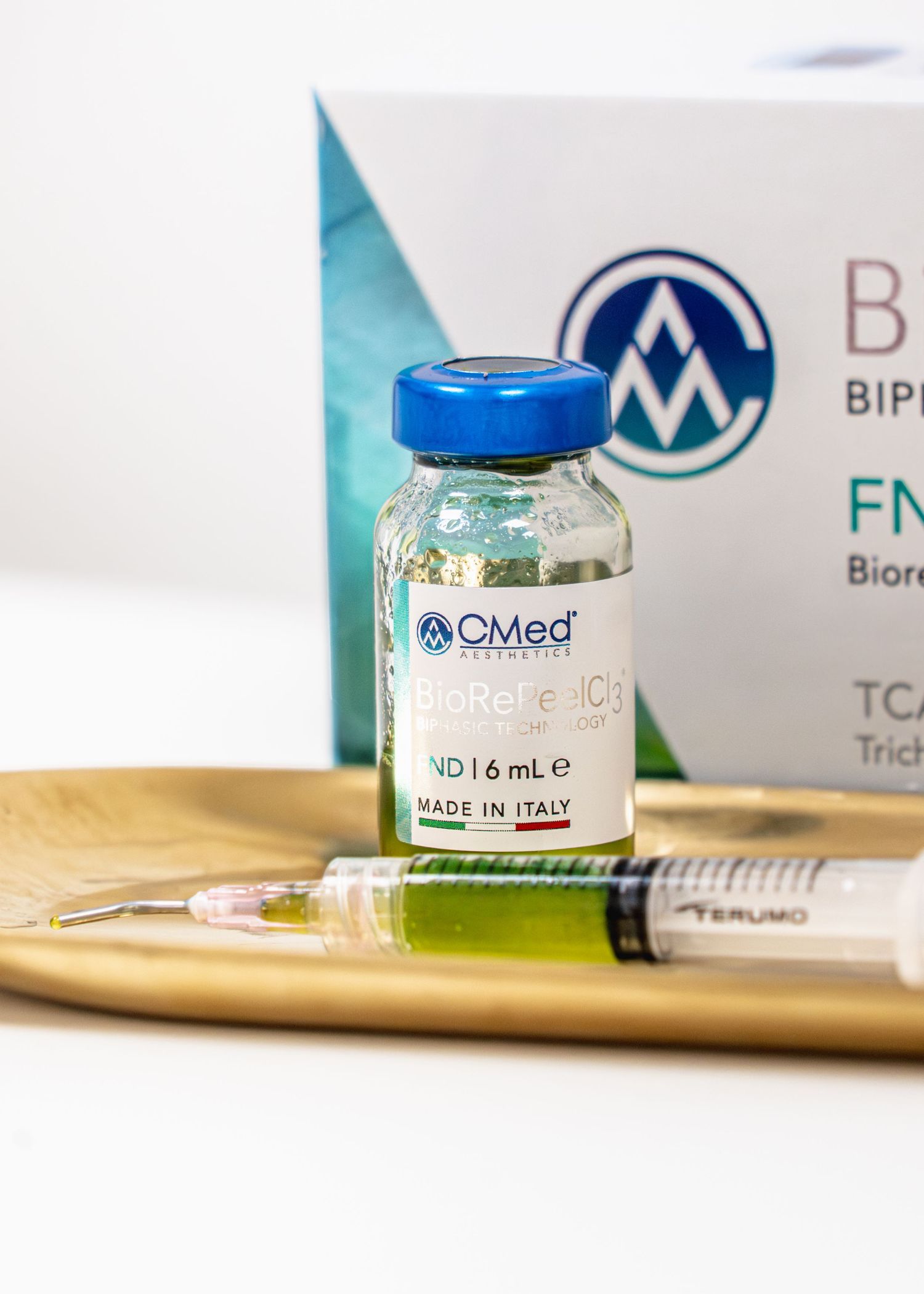 CMed BioRete vial made in Italy with syringe on gold tray, beside product box.