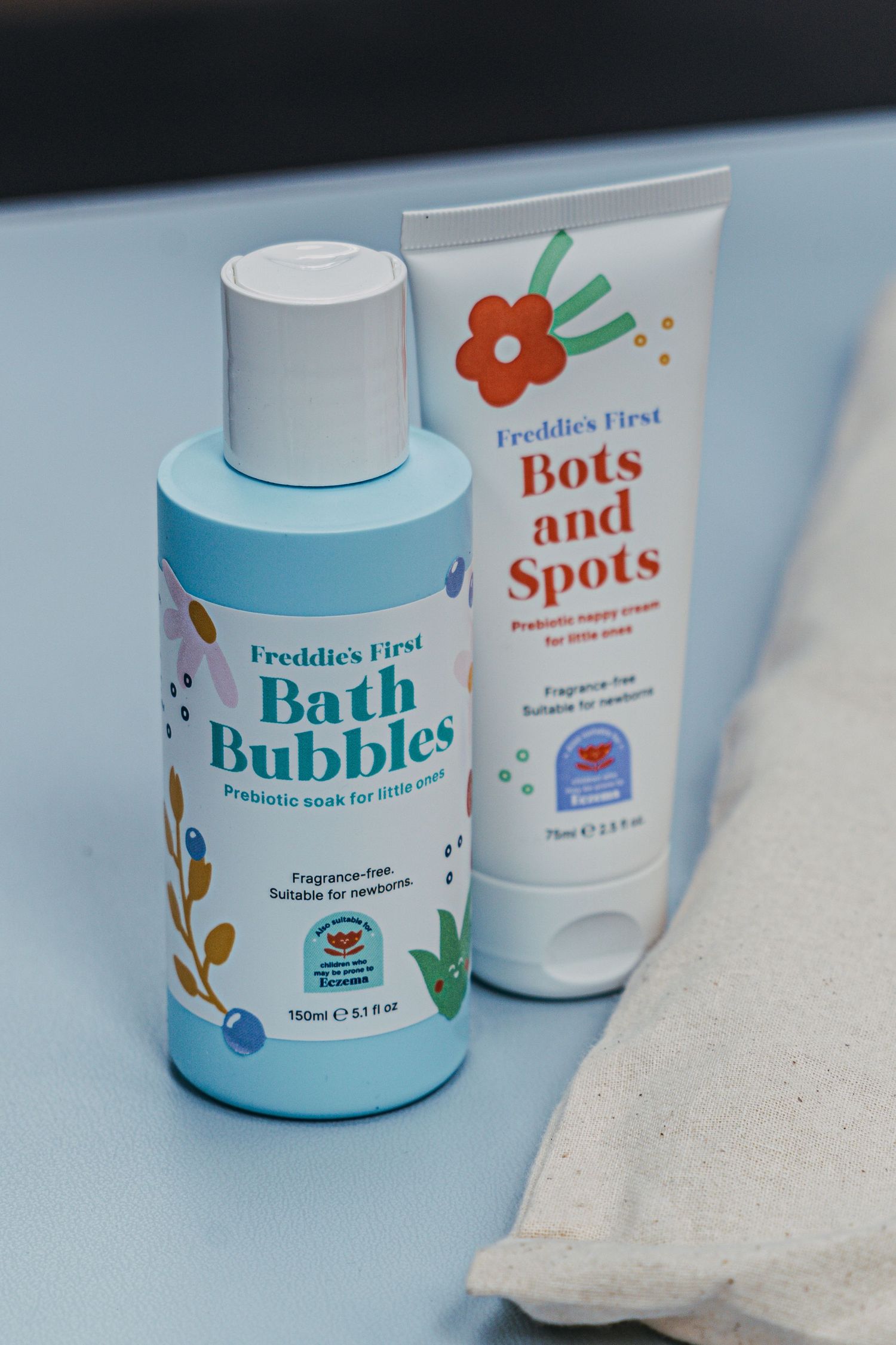 Several blue and white bath product containers displayed in a row with minimal branding and clean design aesthetic.