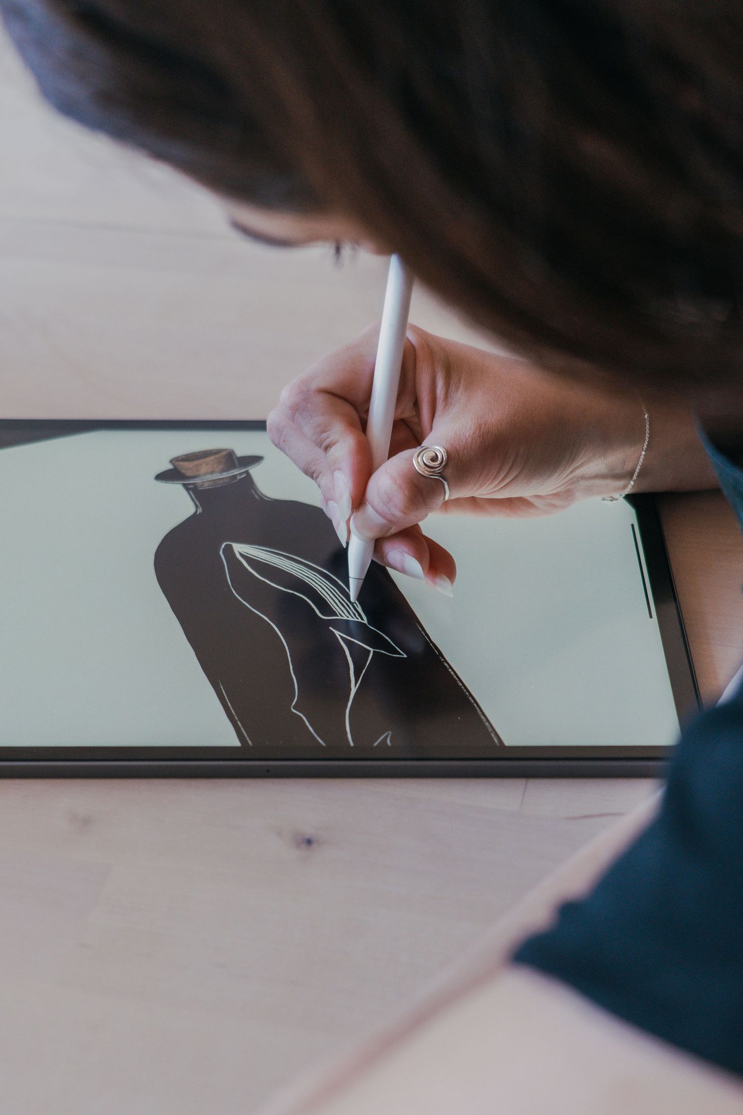 Artist drawing a minimalist line art illustration of lips on a digital tablet with a stylus.