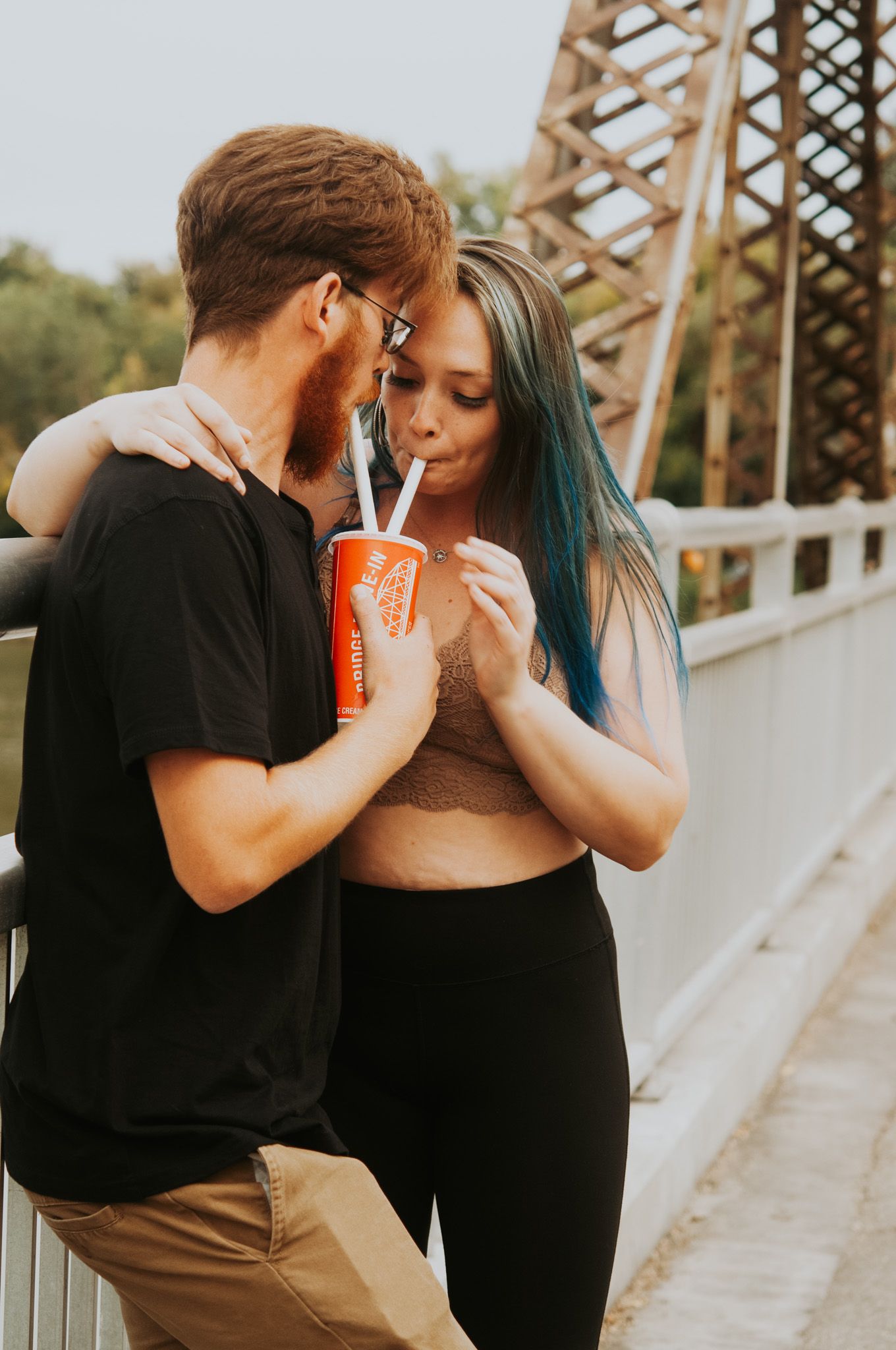 couple shares milkshake at ice cream shop at bridge