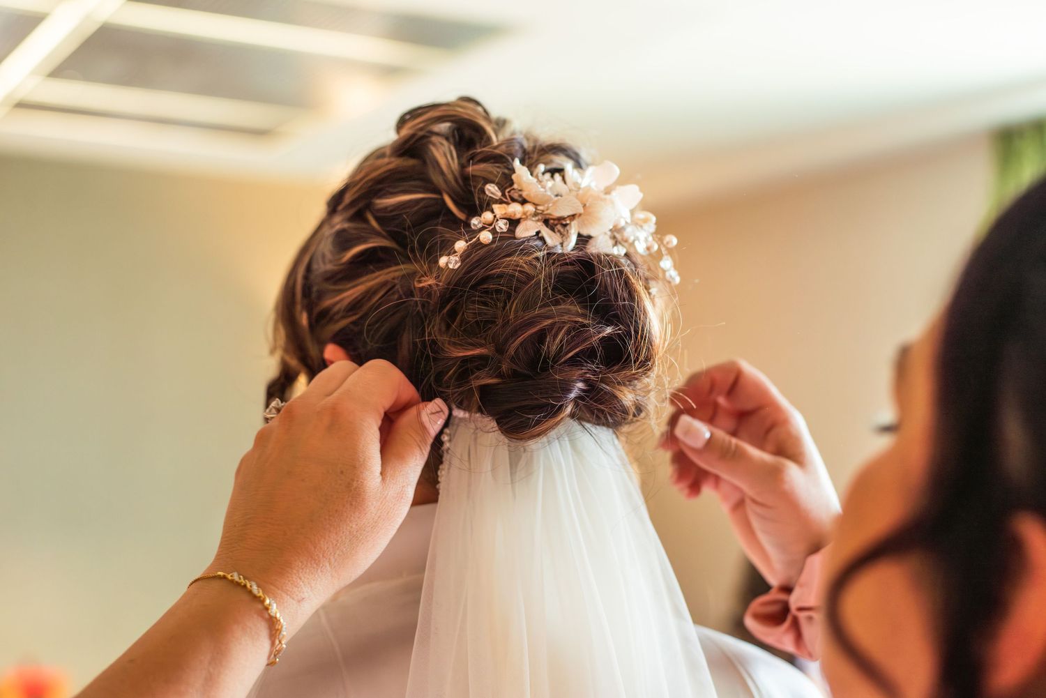 woman helps bride adjust hair