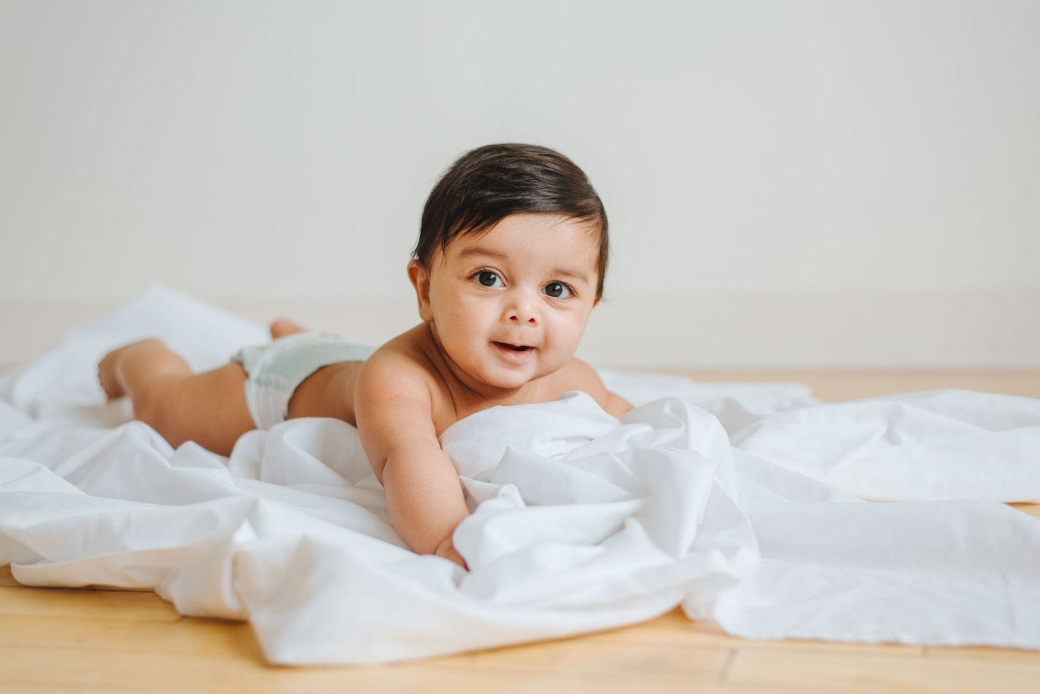 Baby lays on tummy on floor