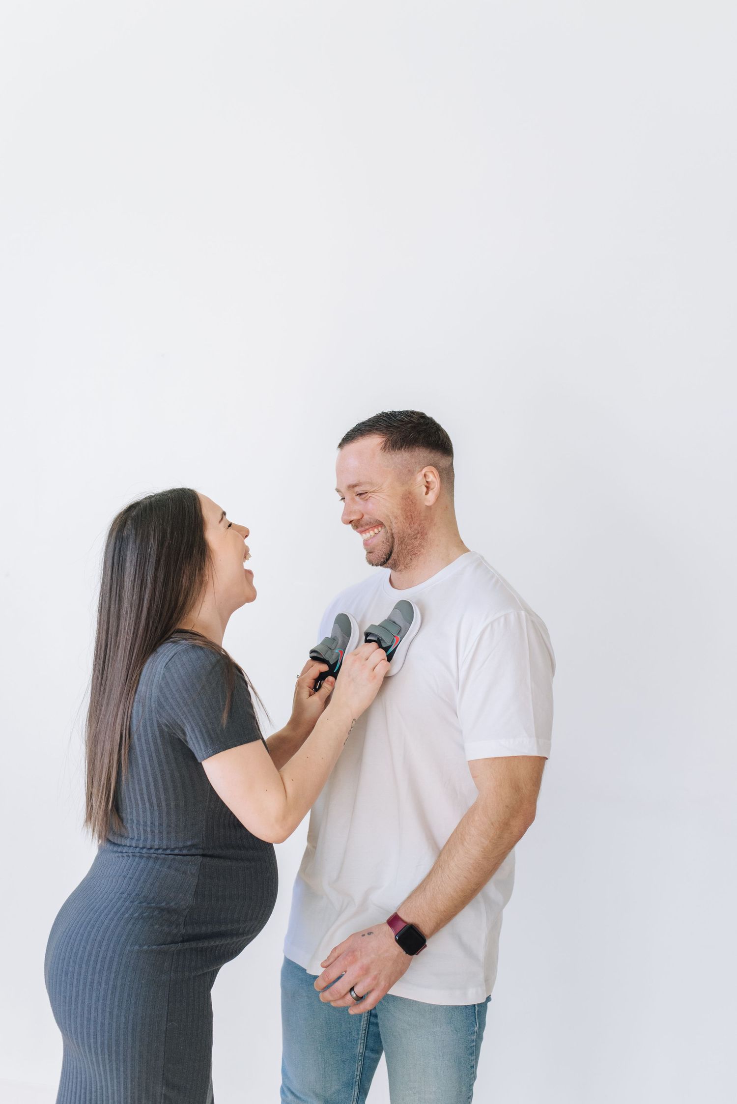 man embraces pregnant wife from behind