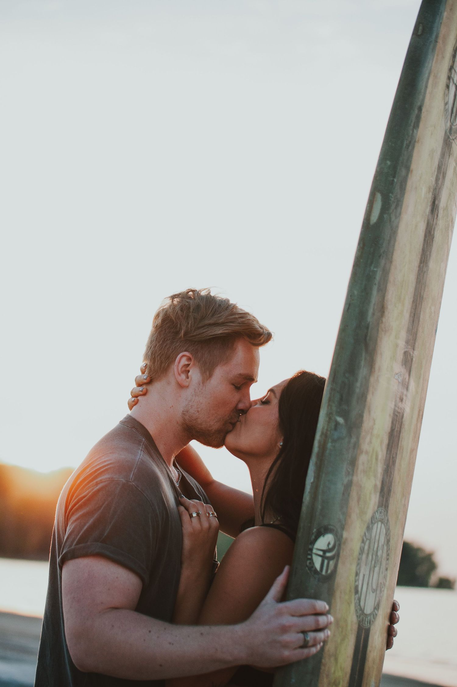 Couple kiss with surf board