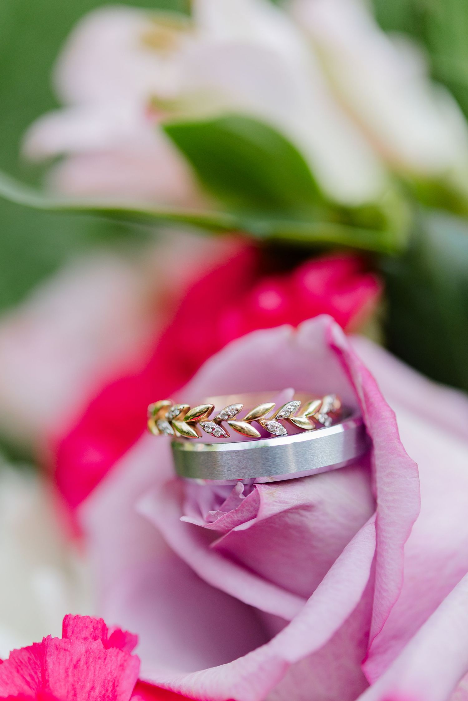 Couples wedding ring sits on bridal bouquet