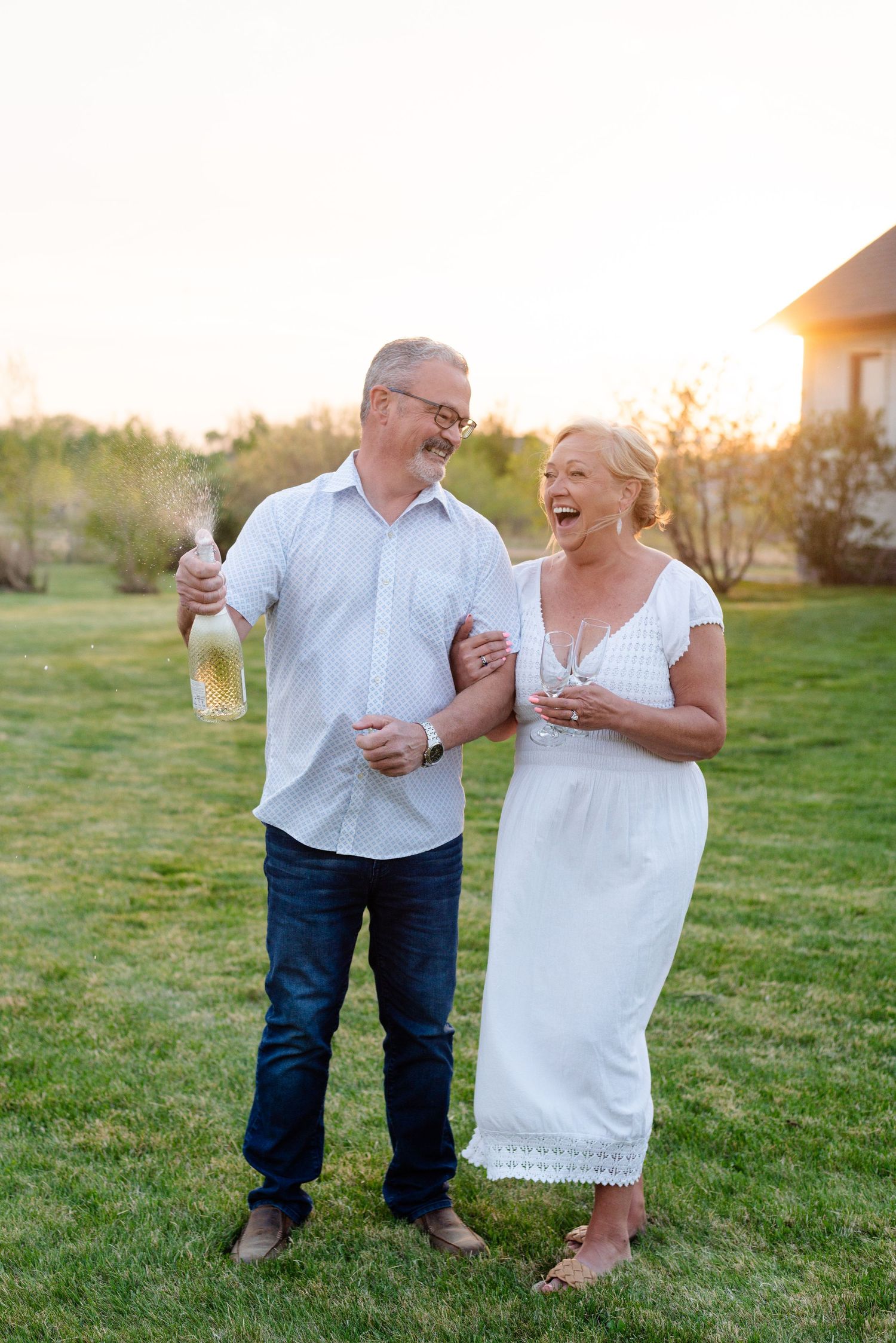 Couple laughs as they spray champagne