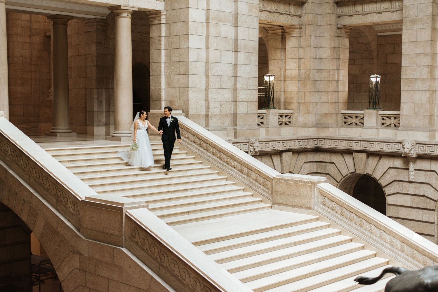 couple walk down staircase on wedding day