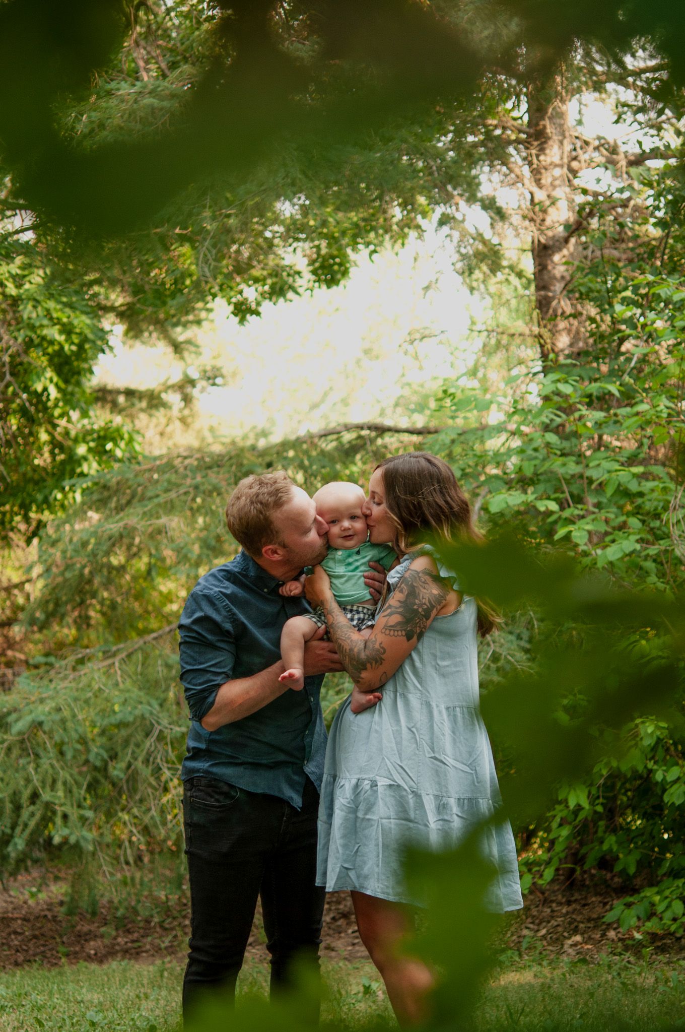 Mom & dad kissing baby boy