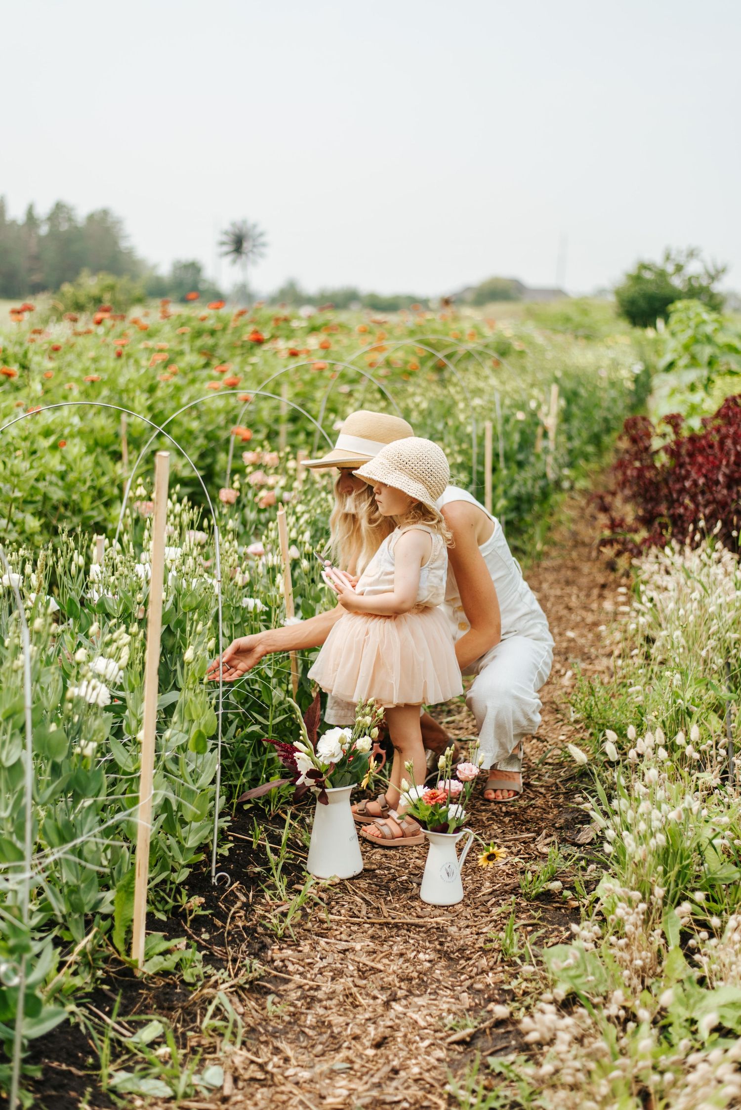 Mom & daughter pick flowers in flower garden