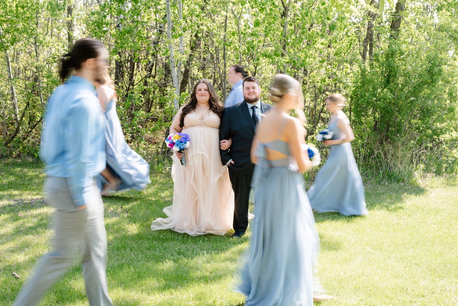 wedding party walking around bride and groom at a fast pace