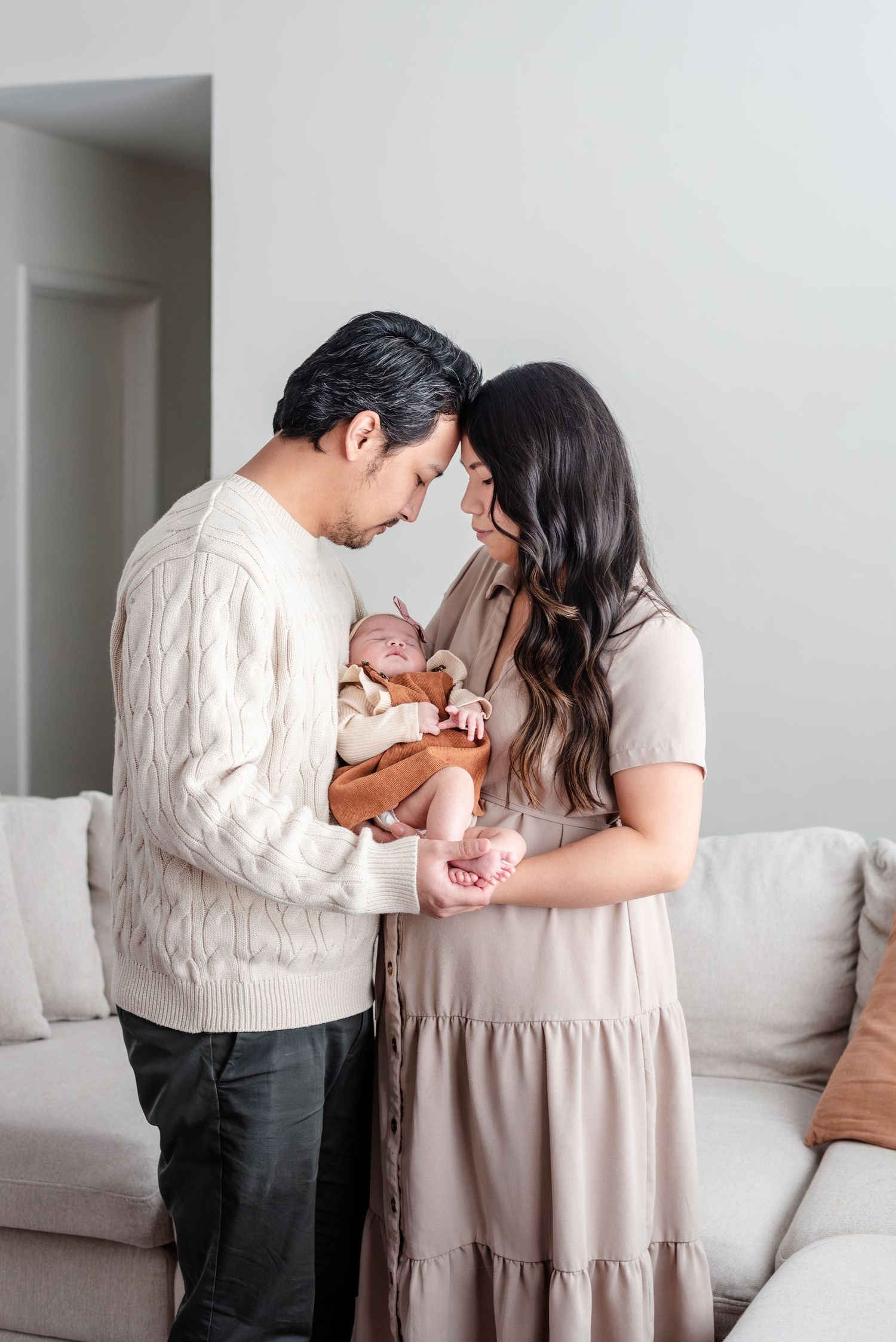 Mom and dad hold baby in their living room