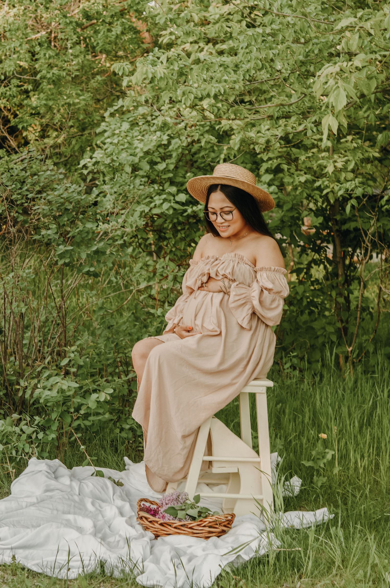 Pregnant woman holds belly in park