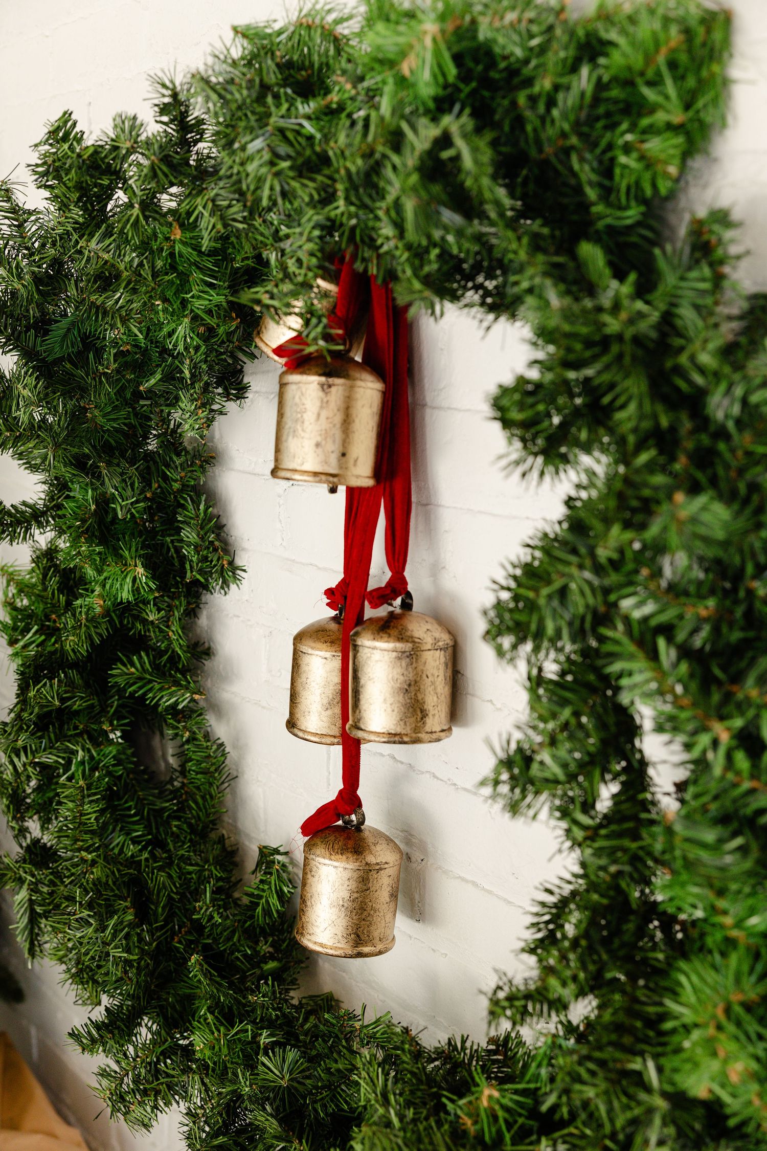 Minimalist xmas set up with brown presents, bells hanging from wreath