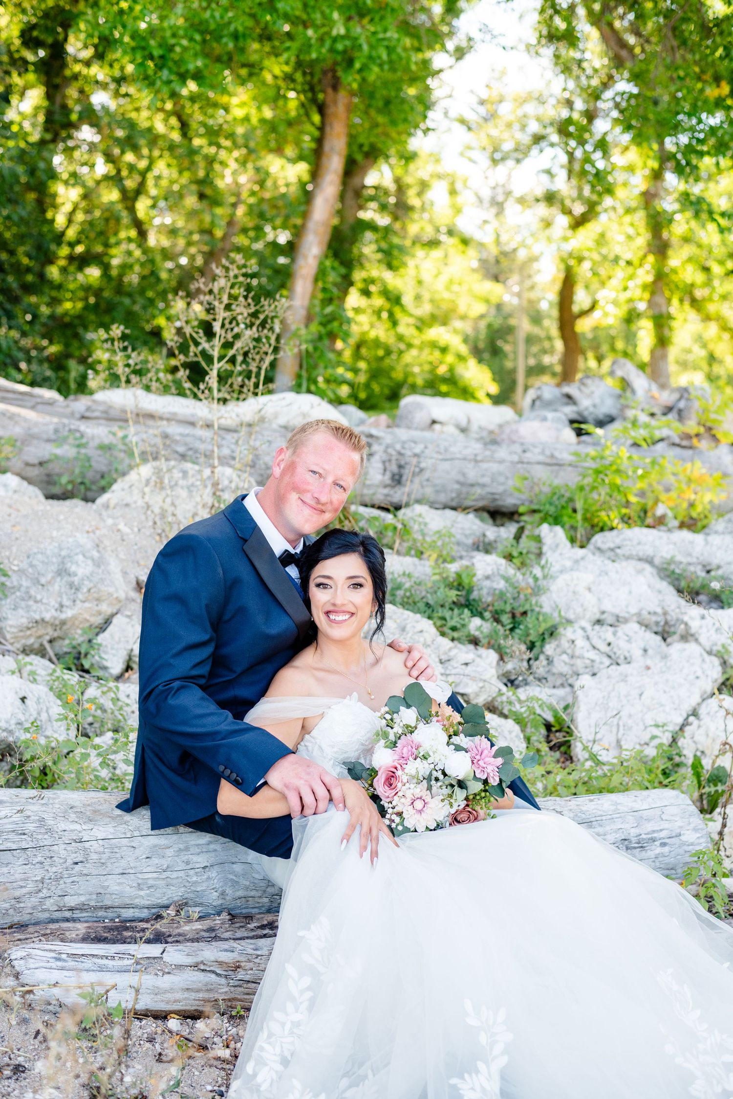 couple sit on beach on wedding day