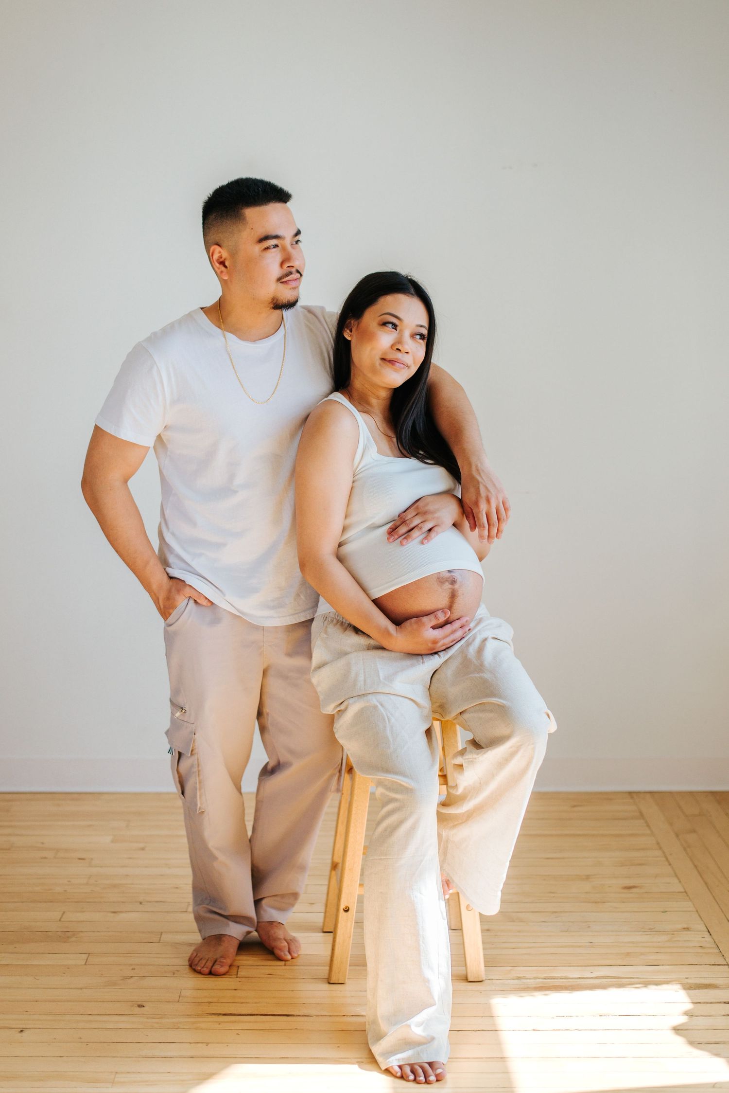 Pregnant couple pose in studio