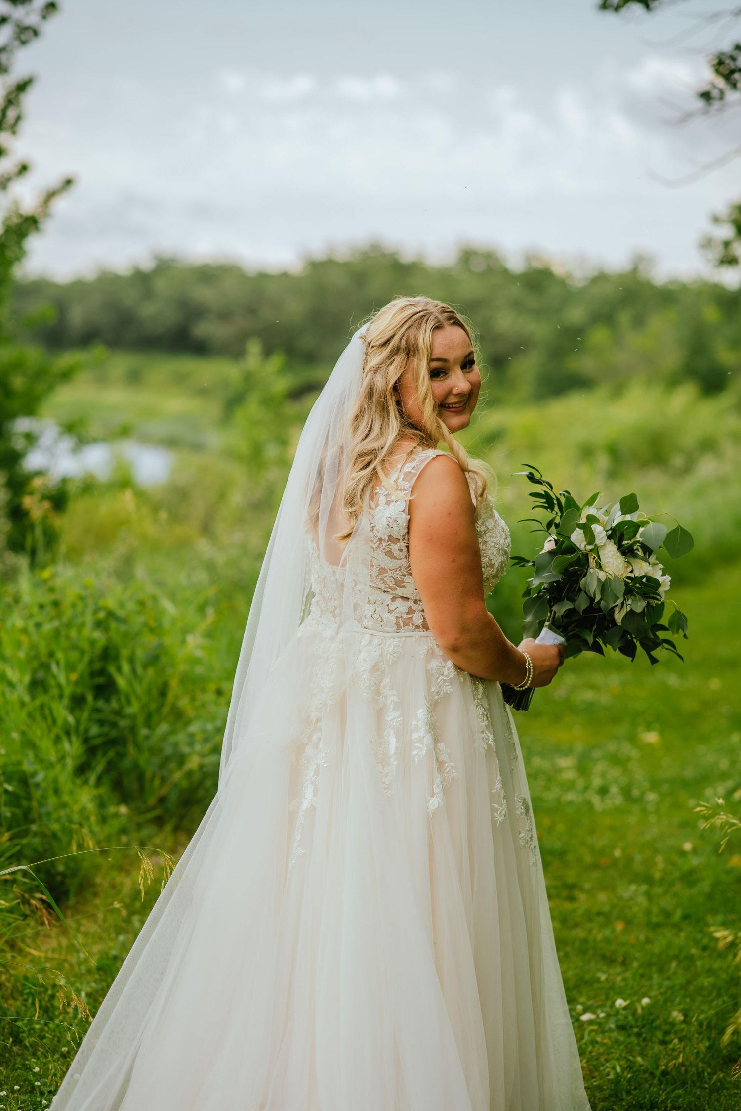 Bride walks down green path
