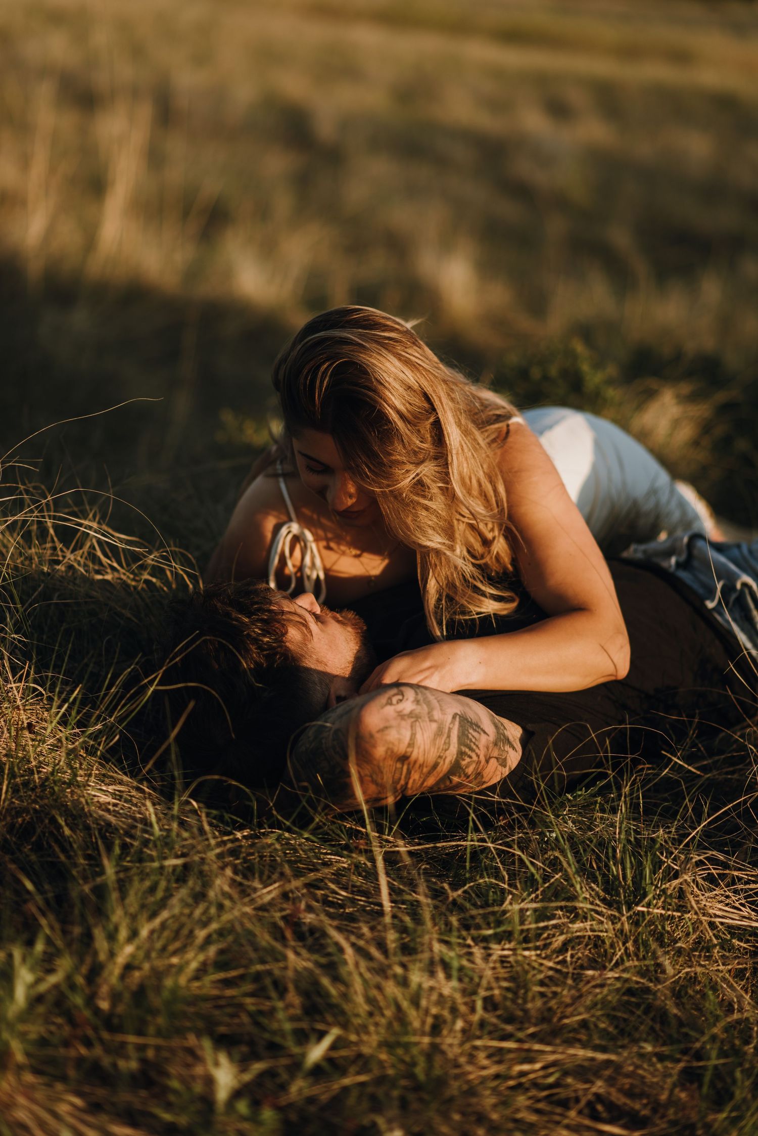 man and woman kiss rolling in feild