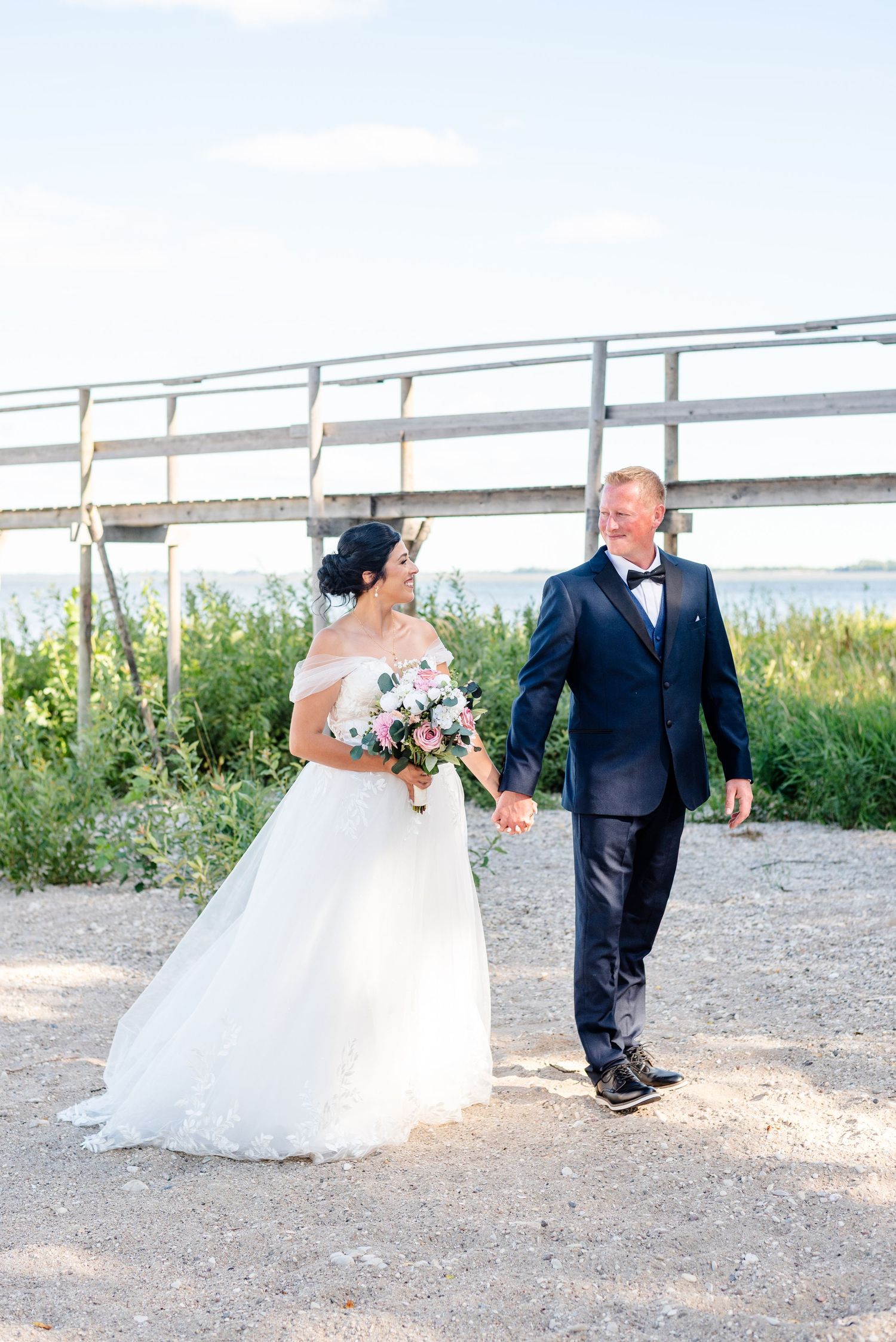 couple enjoy a walk on the beach on their wedding day