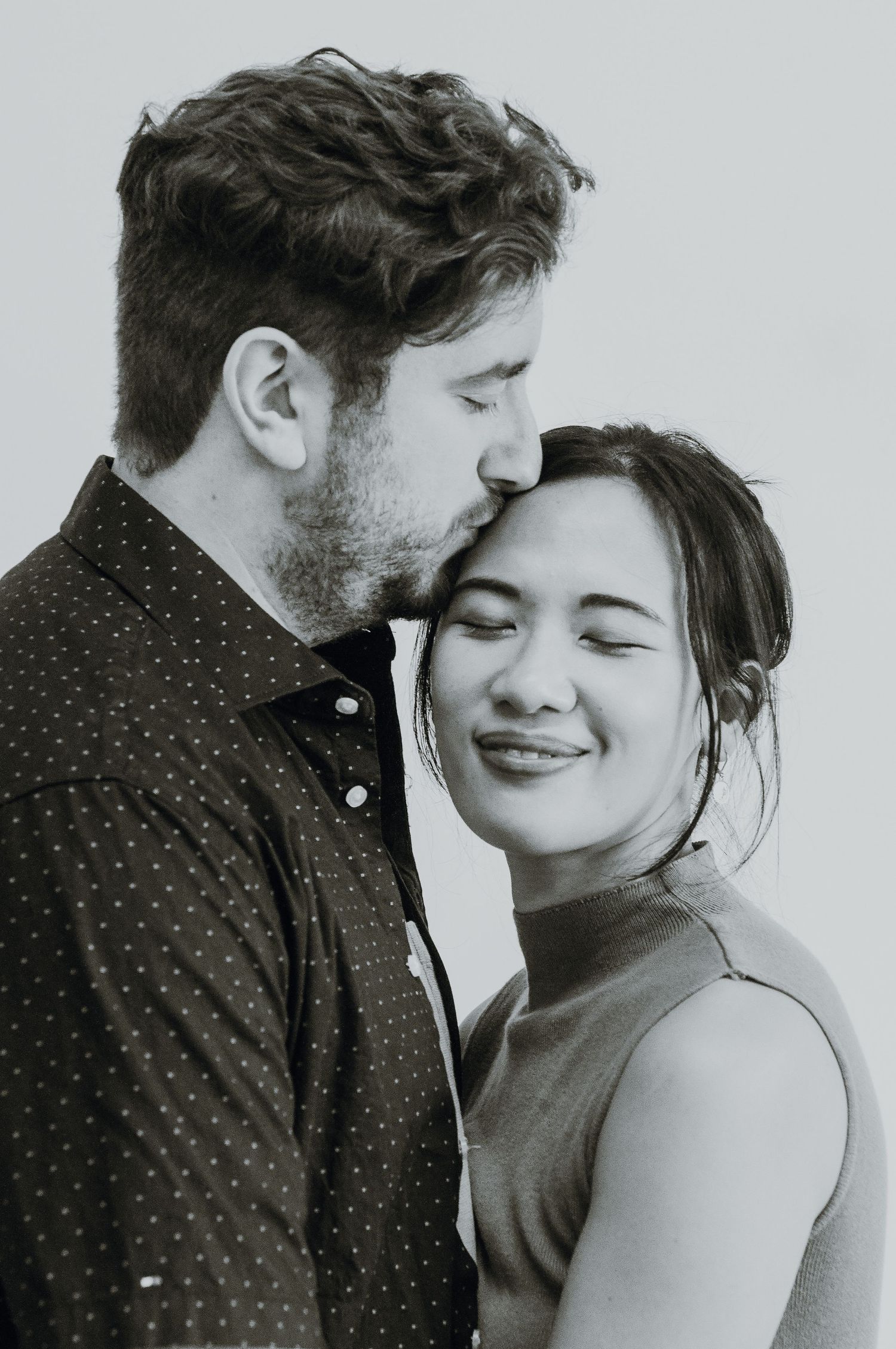 Man kisses woman on side of head