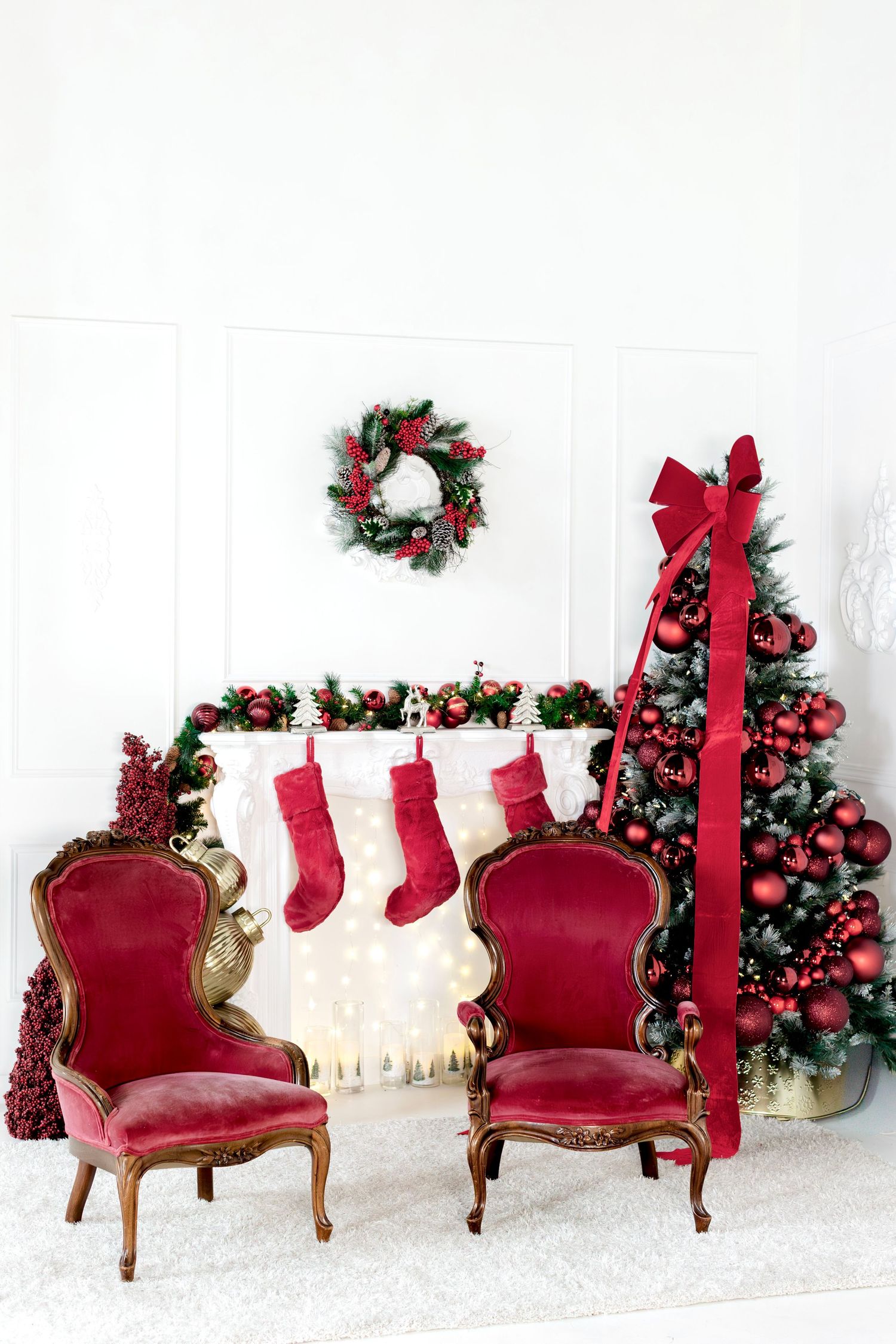 two old looking chairs, in front of fireplace and large xmas tree