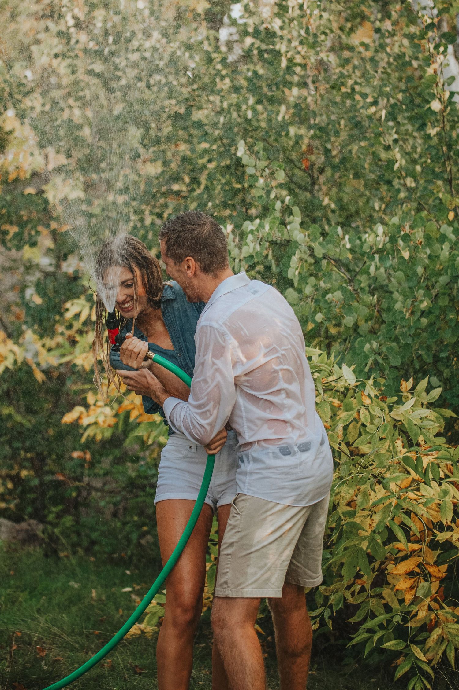 Couple froliks under the garden hose