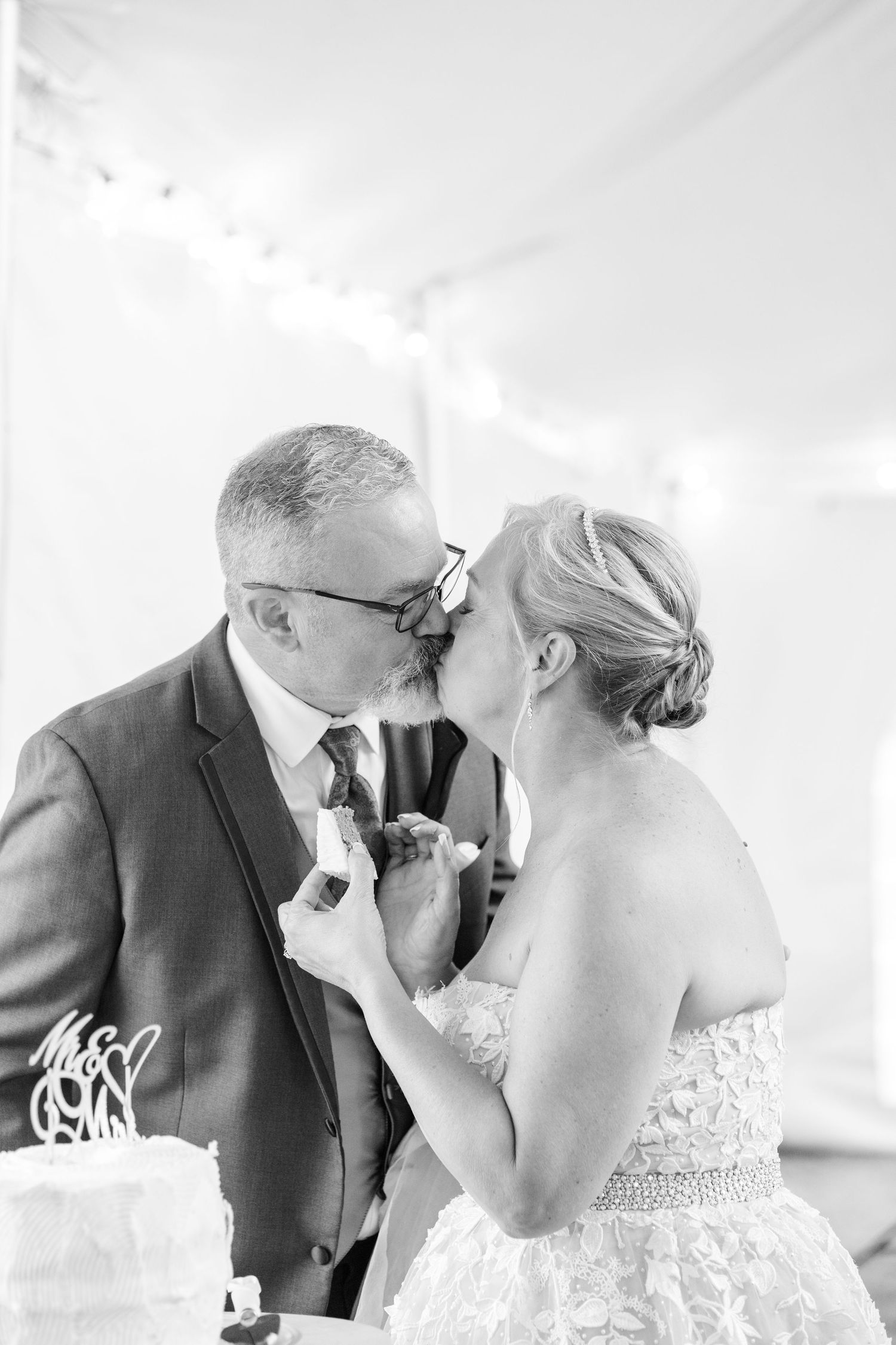 bride and groom kiss after cutting cake