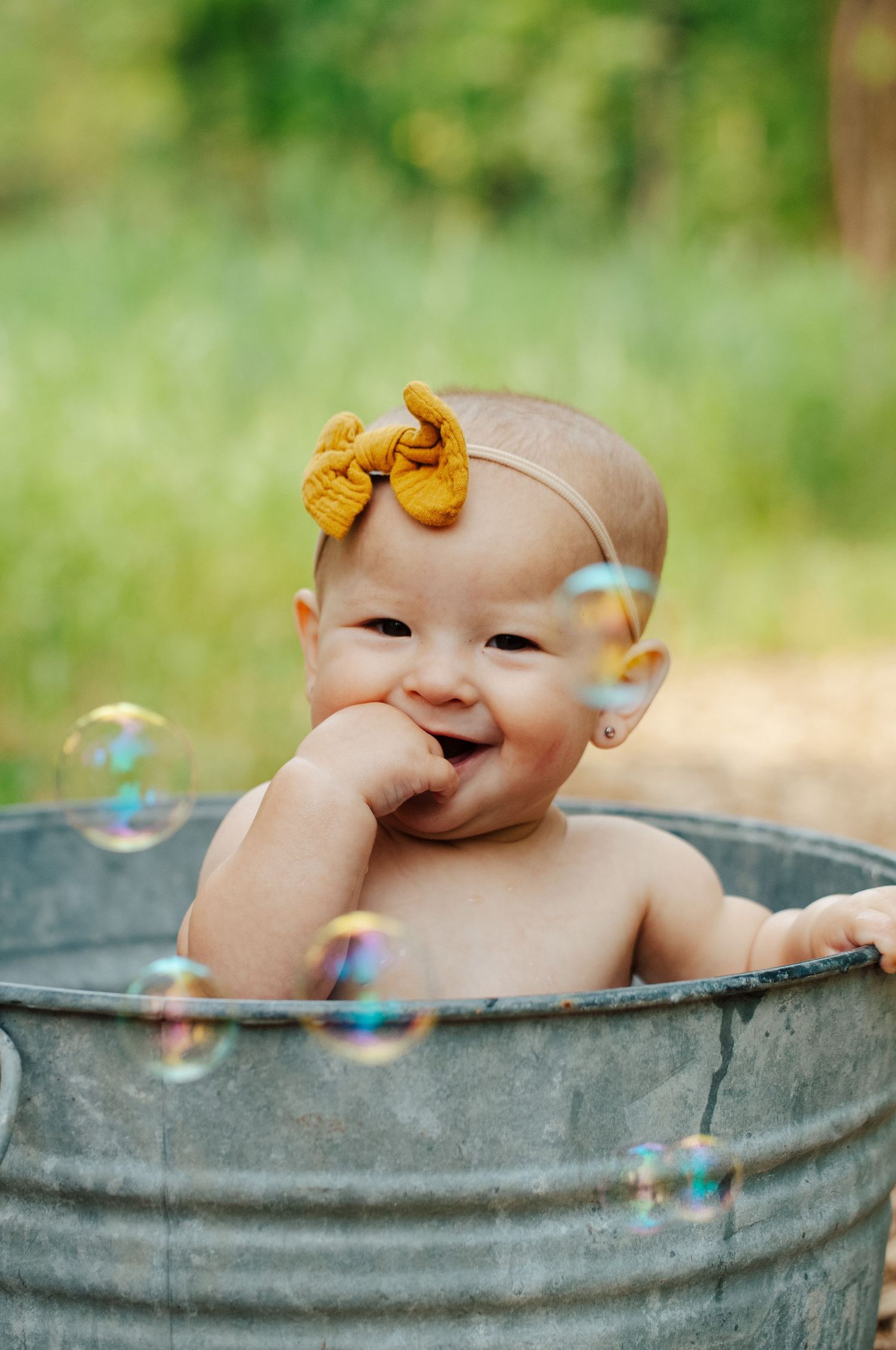 Baby smiles in bucket during photoshoot