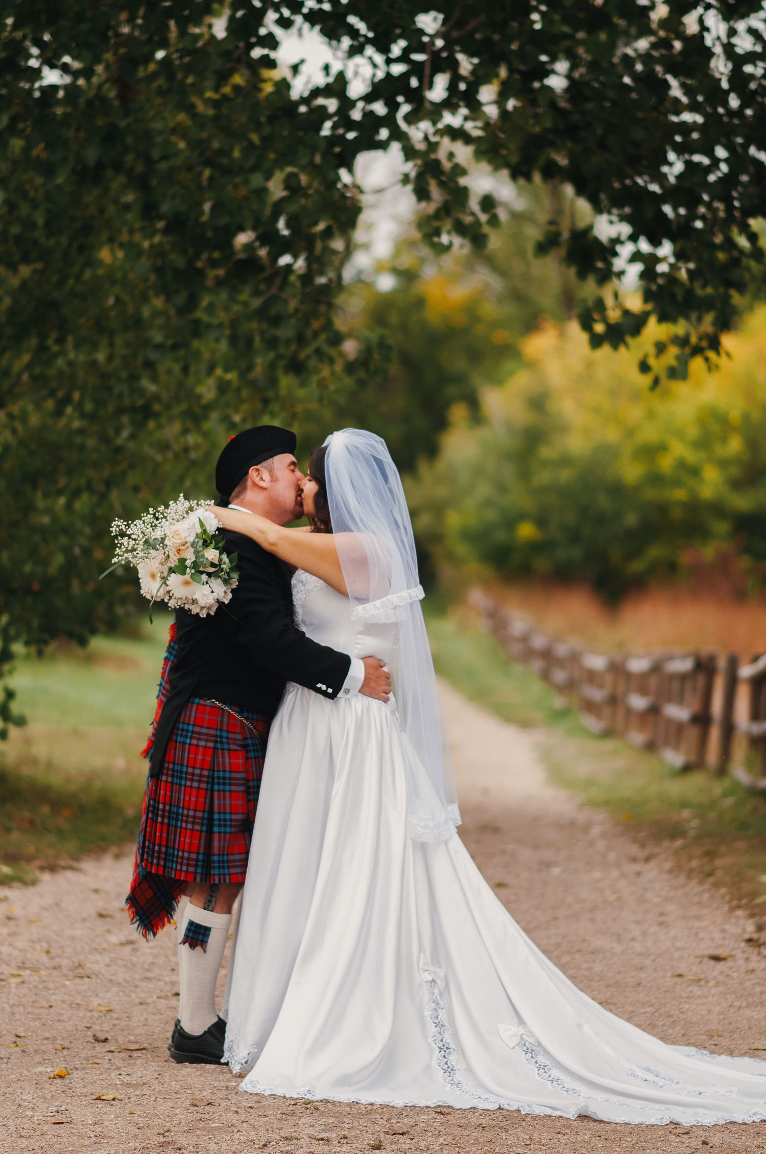 couple kiss on wedding day in a park