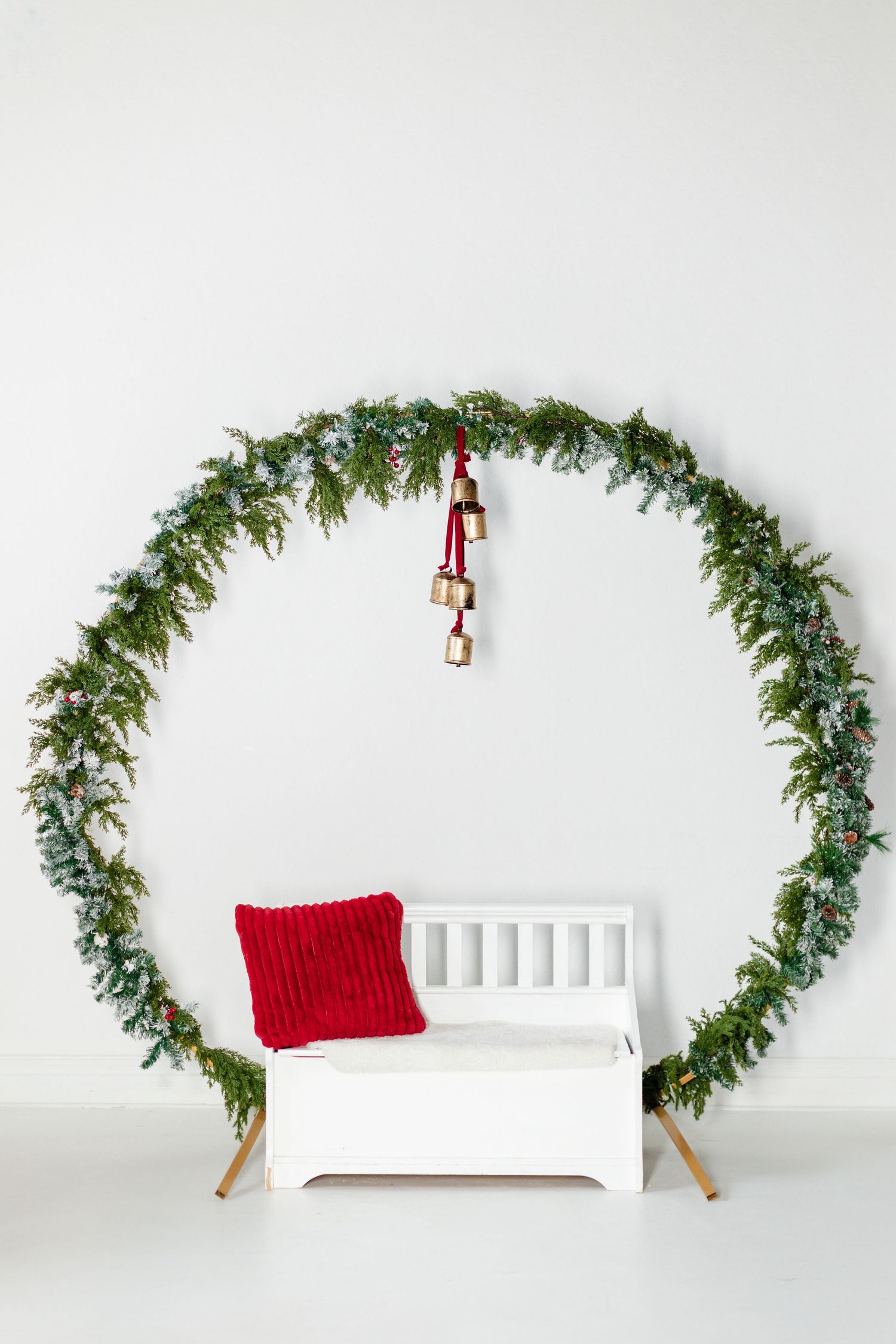 photo of large wreath with a bench under it for a Christmas set up at a photo studio