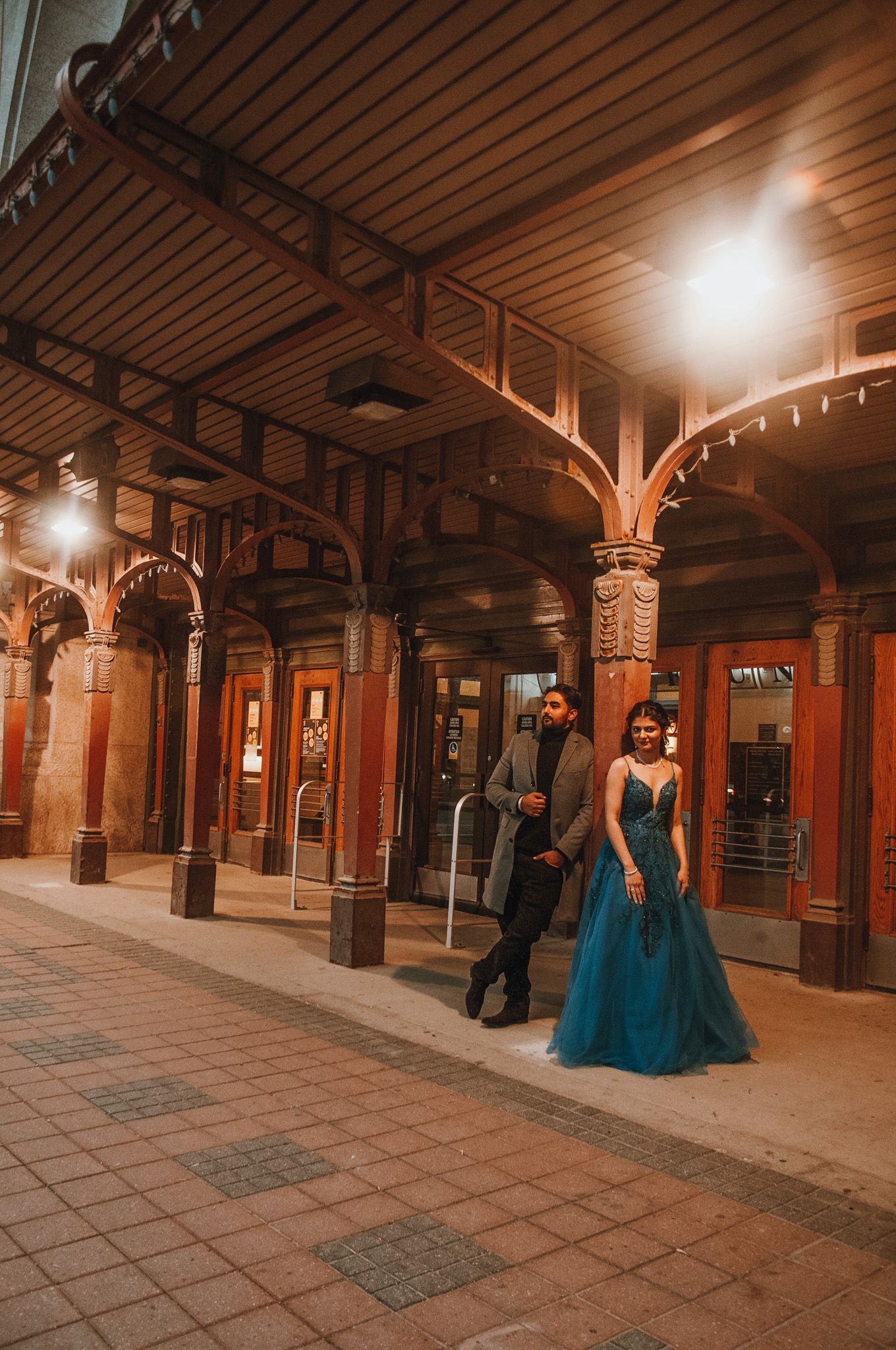 Couple leans againts pole at railway station