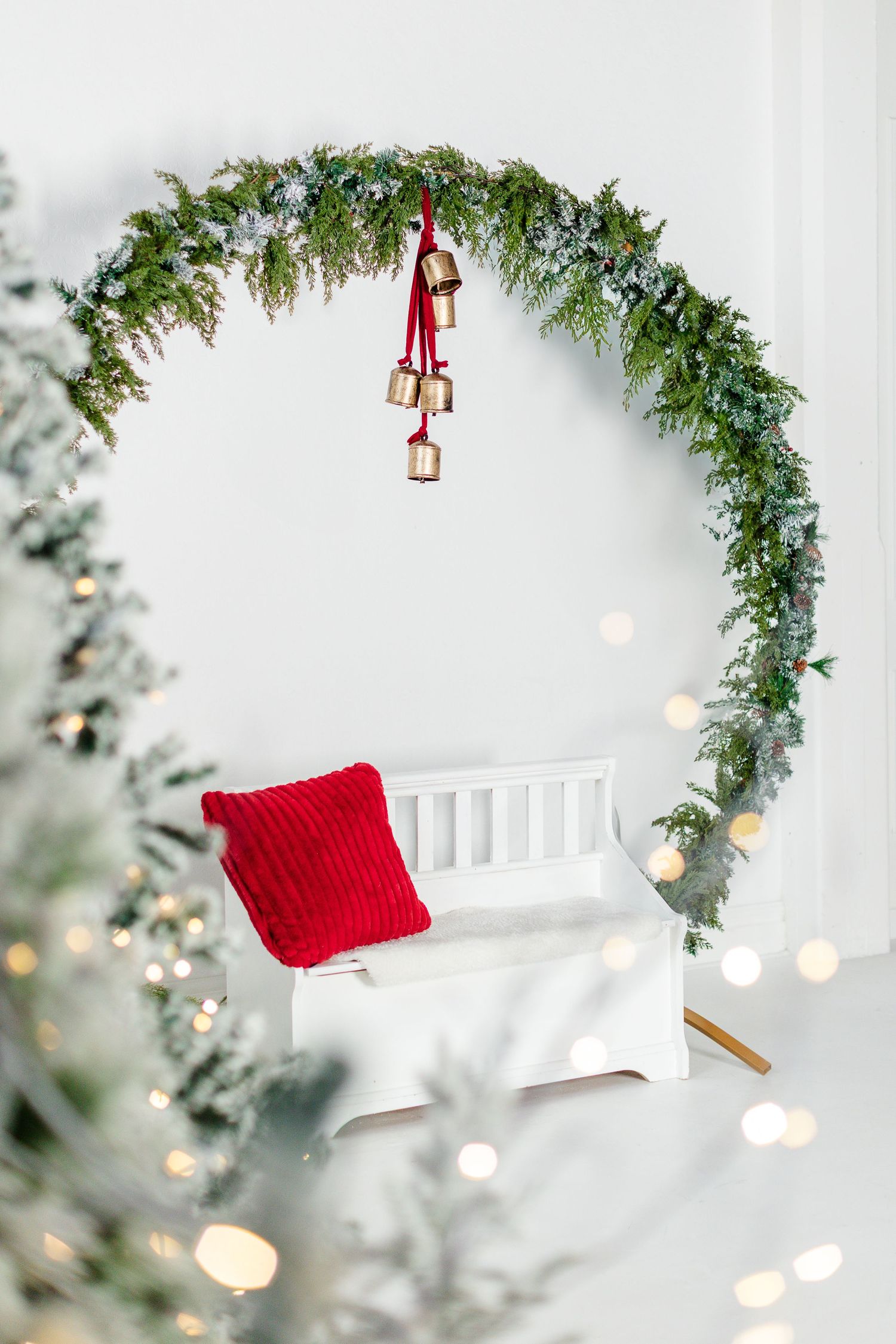 photo of large wreath with a bench under it for a Christmas set up at a photo studio