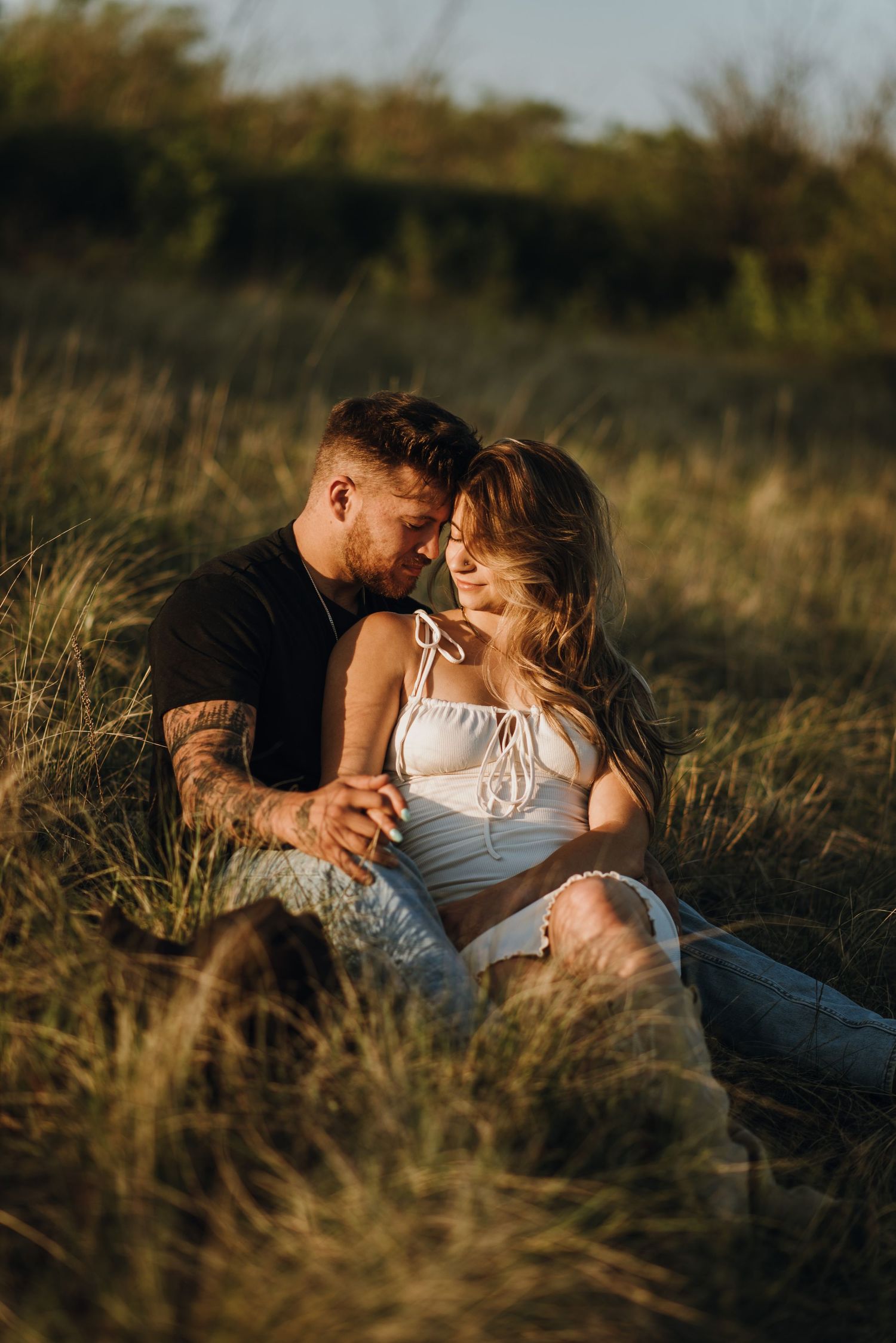 Couple hold eachother in feild
