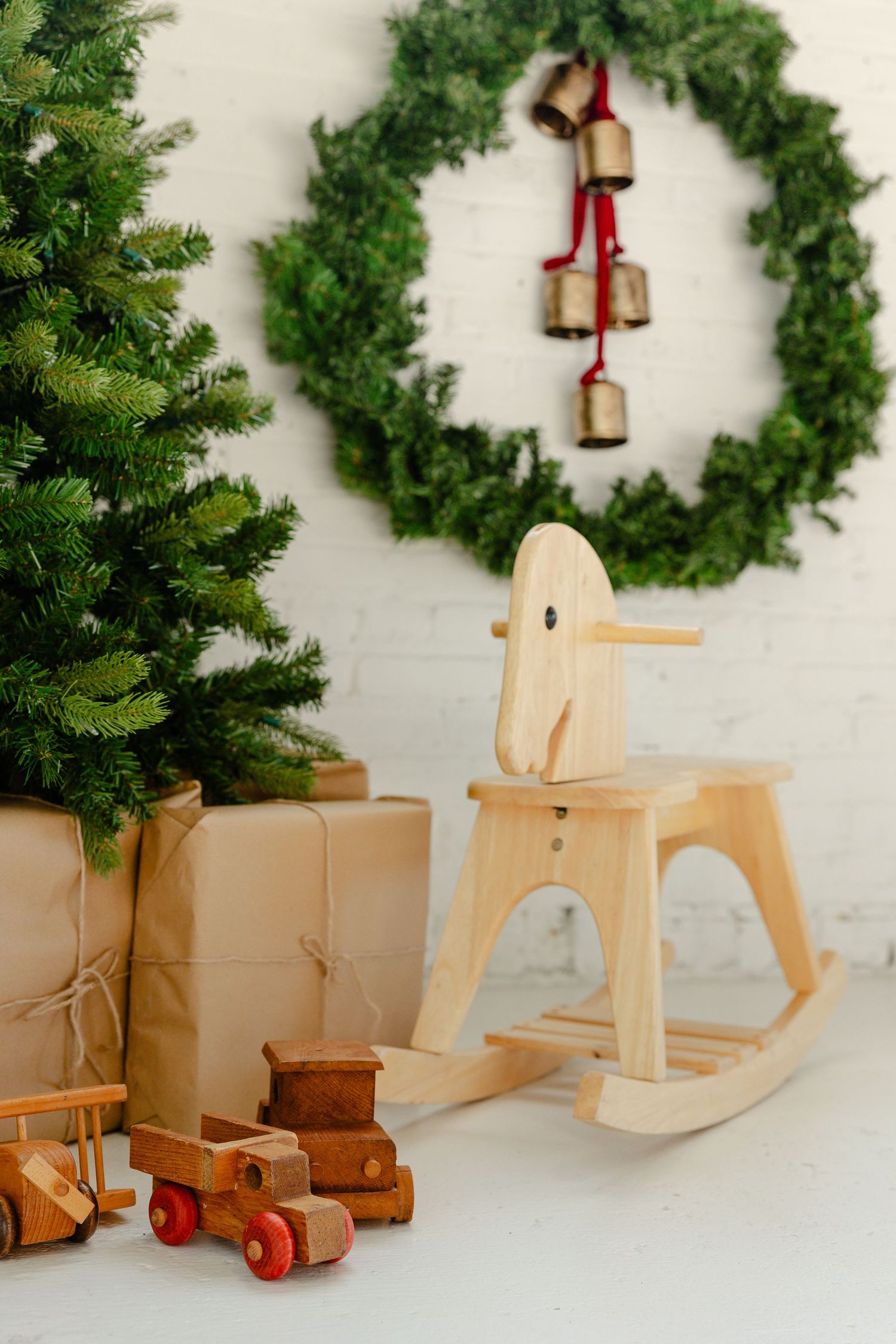 Minimalist xmas set up with brown presents, bells hanging from wreath