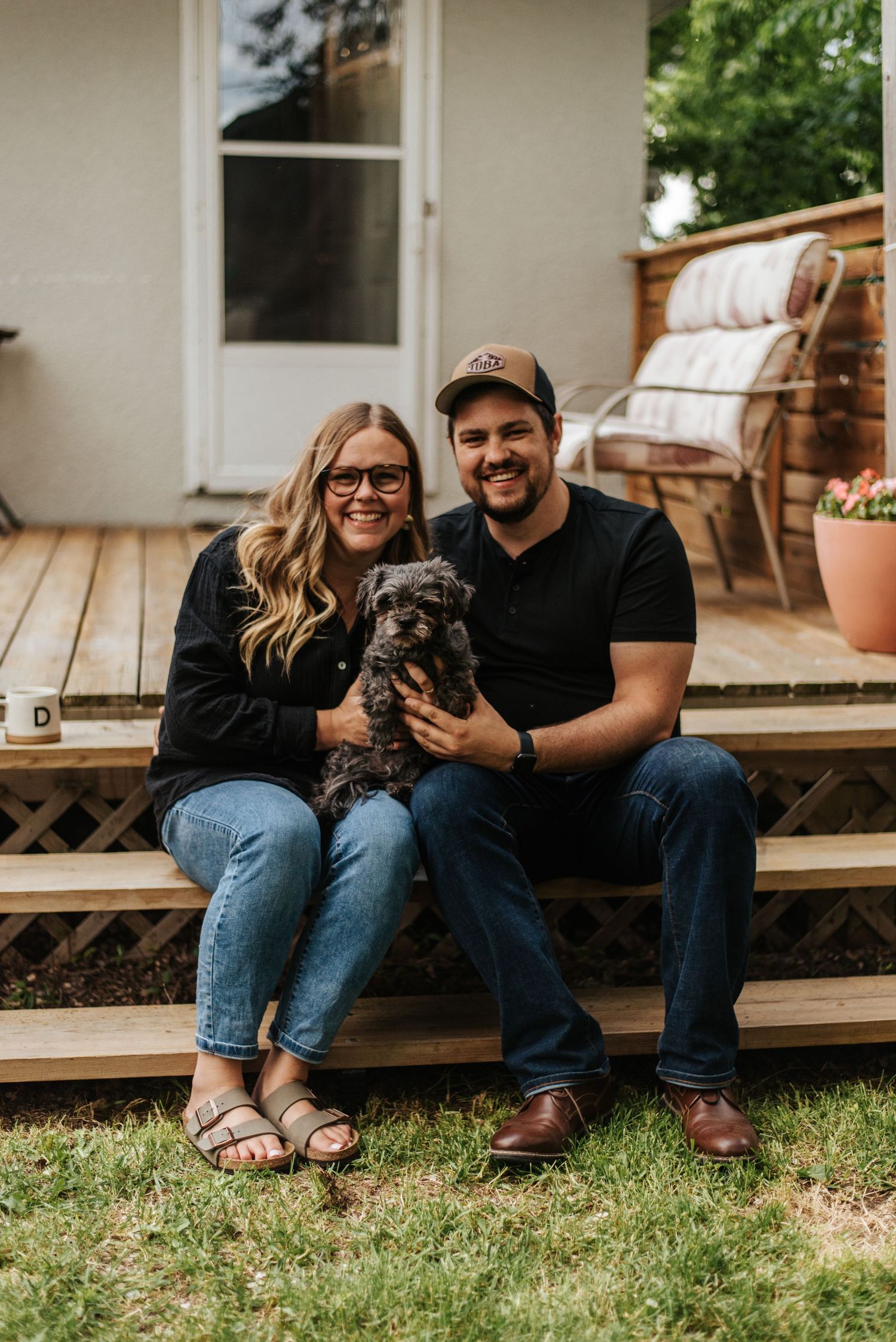 Couple holding dog in backyard