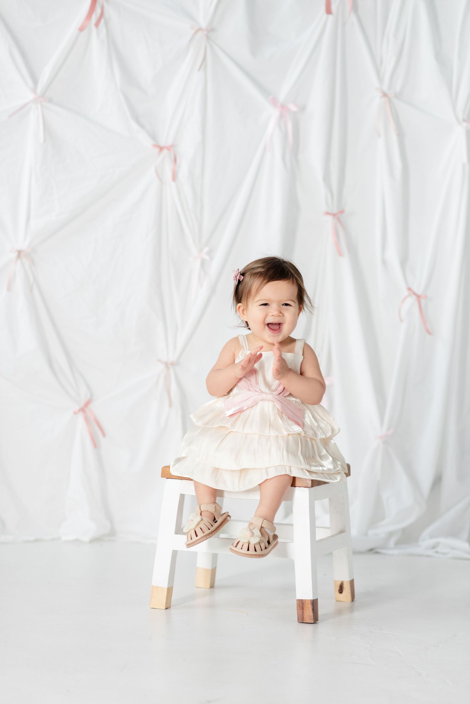 Baby smiling and clapping on white background
