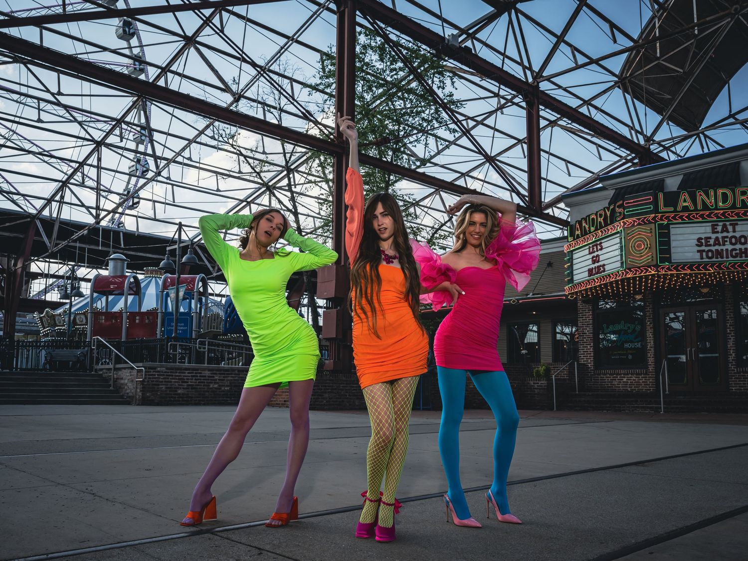 Dancers in colorful neon outfits performing in an urban warehouse space.