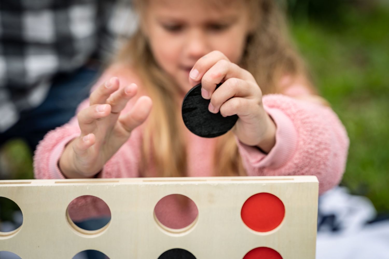 Series of candid moments playing with colorful paint dots on a sunny outdoor day.