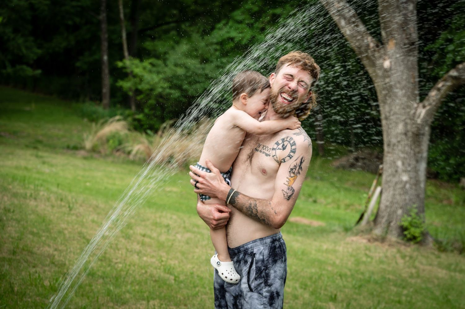 Playful moment in backyard sprinkler on sunny summer day.