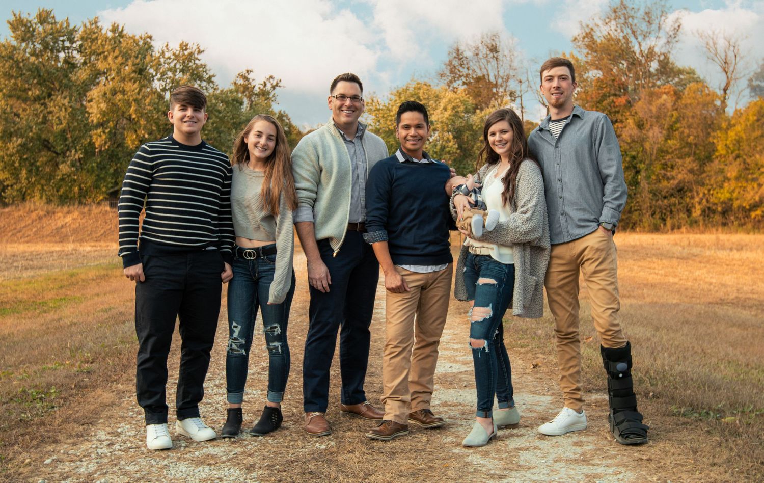 Extended family portrait in autumn setting with golden light and fall foliage.