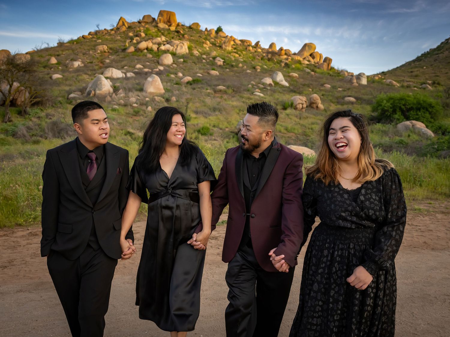 Group photoshoot against rocky mountain backdrop during golden hour.