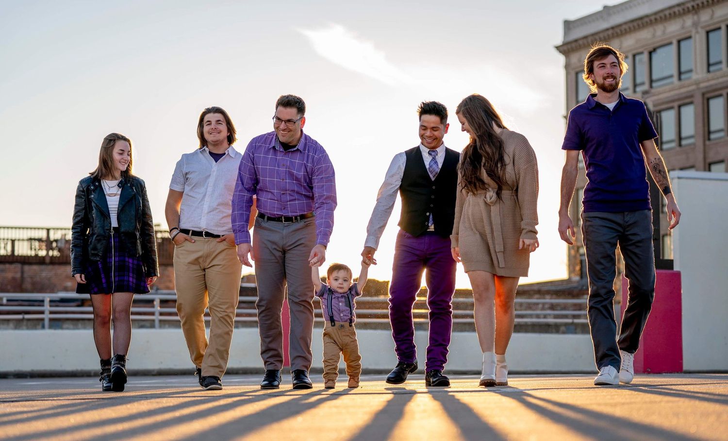 Group walking together on urban steps with long shadows cast by sunset lighting.