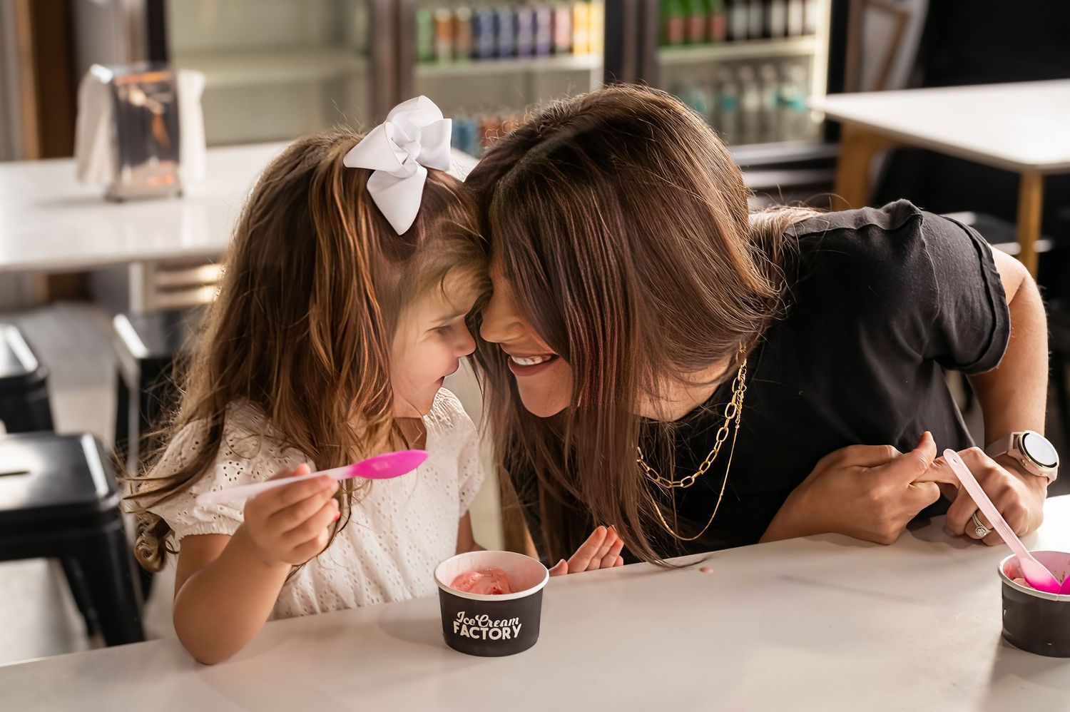 Sharing dessert together at modern ice cream shop counter.