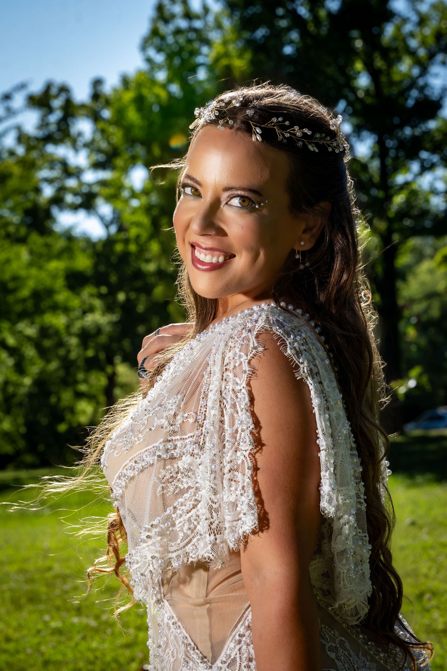 Beautiful lace wedding dress details captured in natural outdoor lighting.
