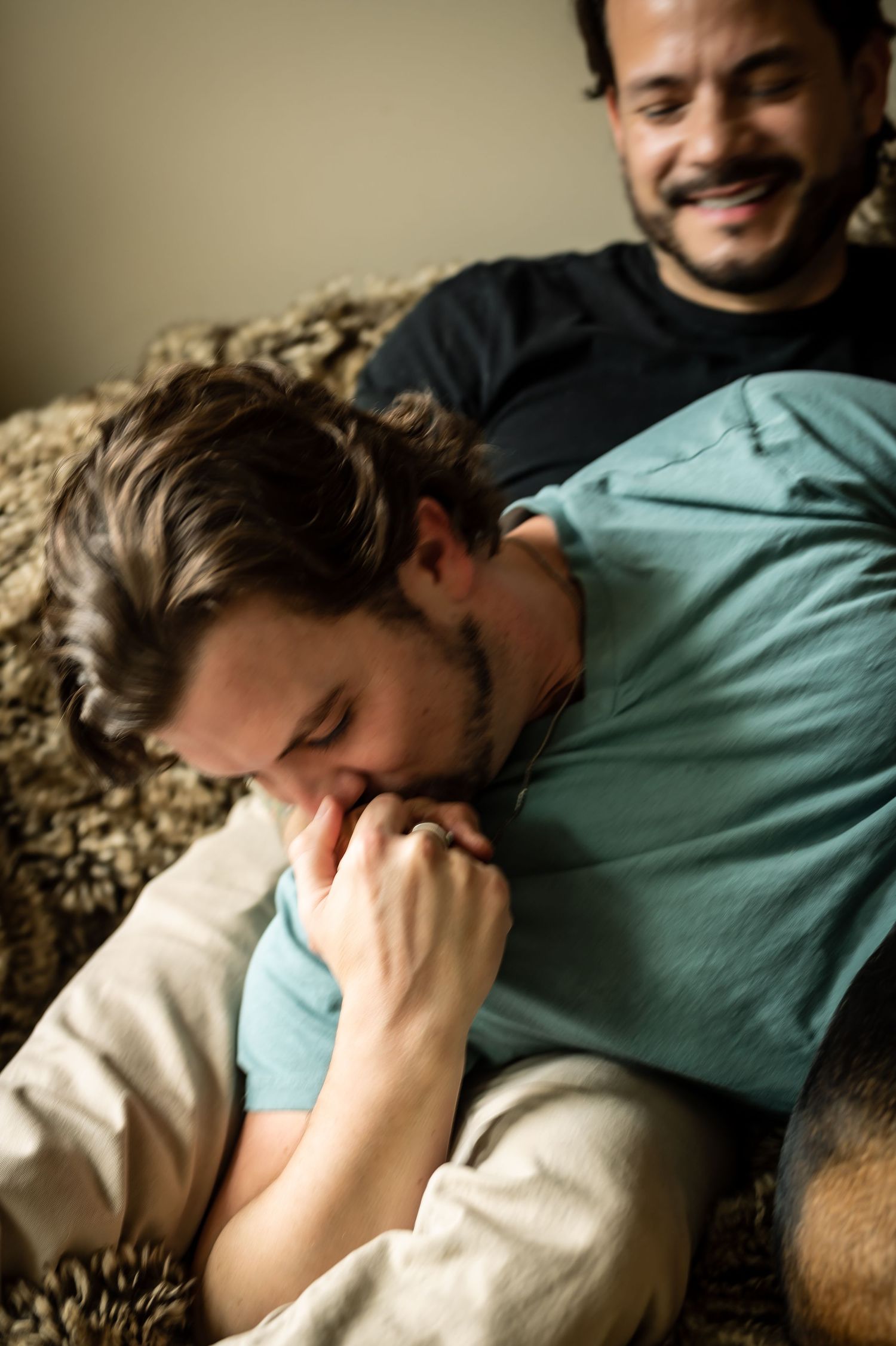 Relaxed candid moments of laughter and comfort on a couch.