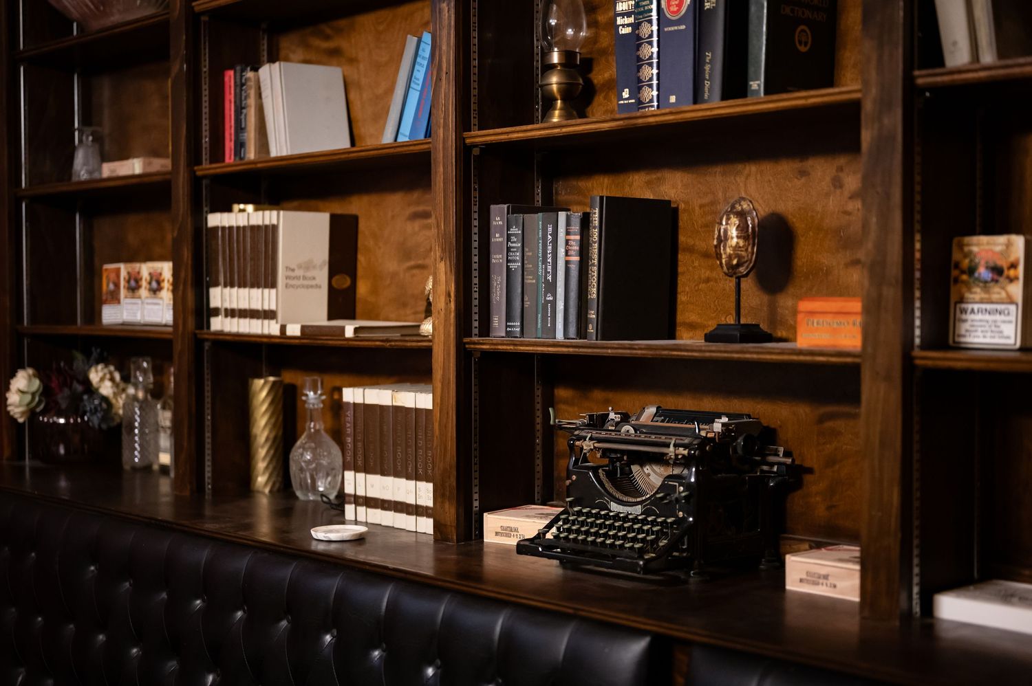 Cozy library interior with wooden bookshelves and leather seating.