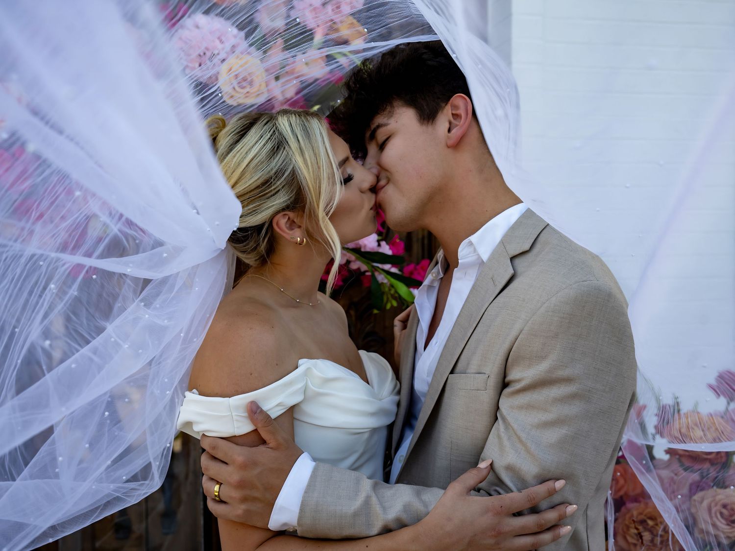 A tender moment between newlyweds under a flowing white veil.