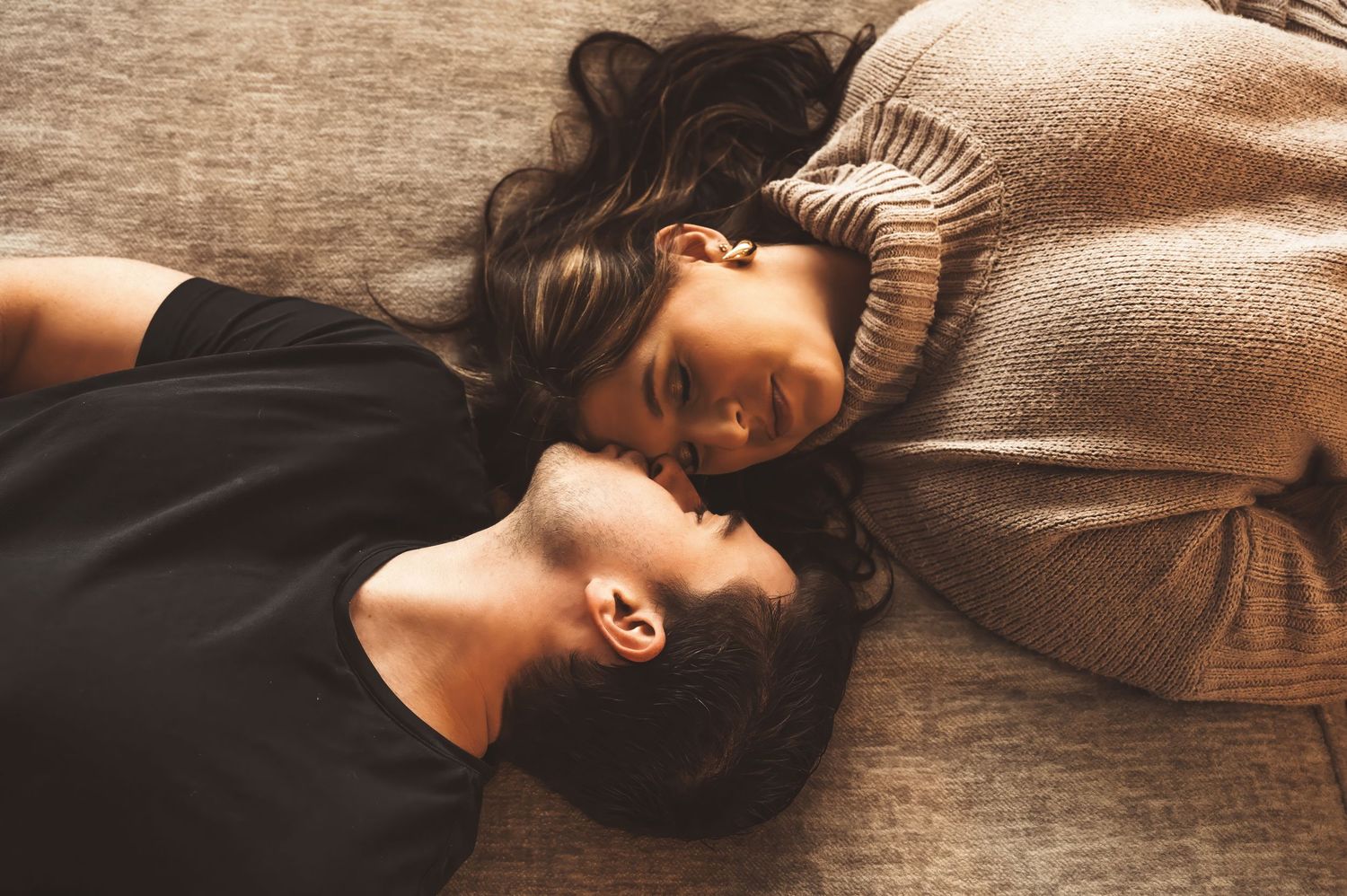 Intimate lifestyle photography capturing tender moments on wooden flooring.