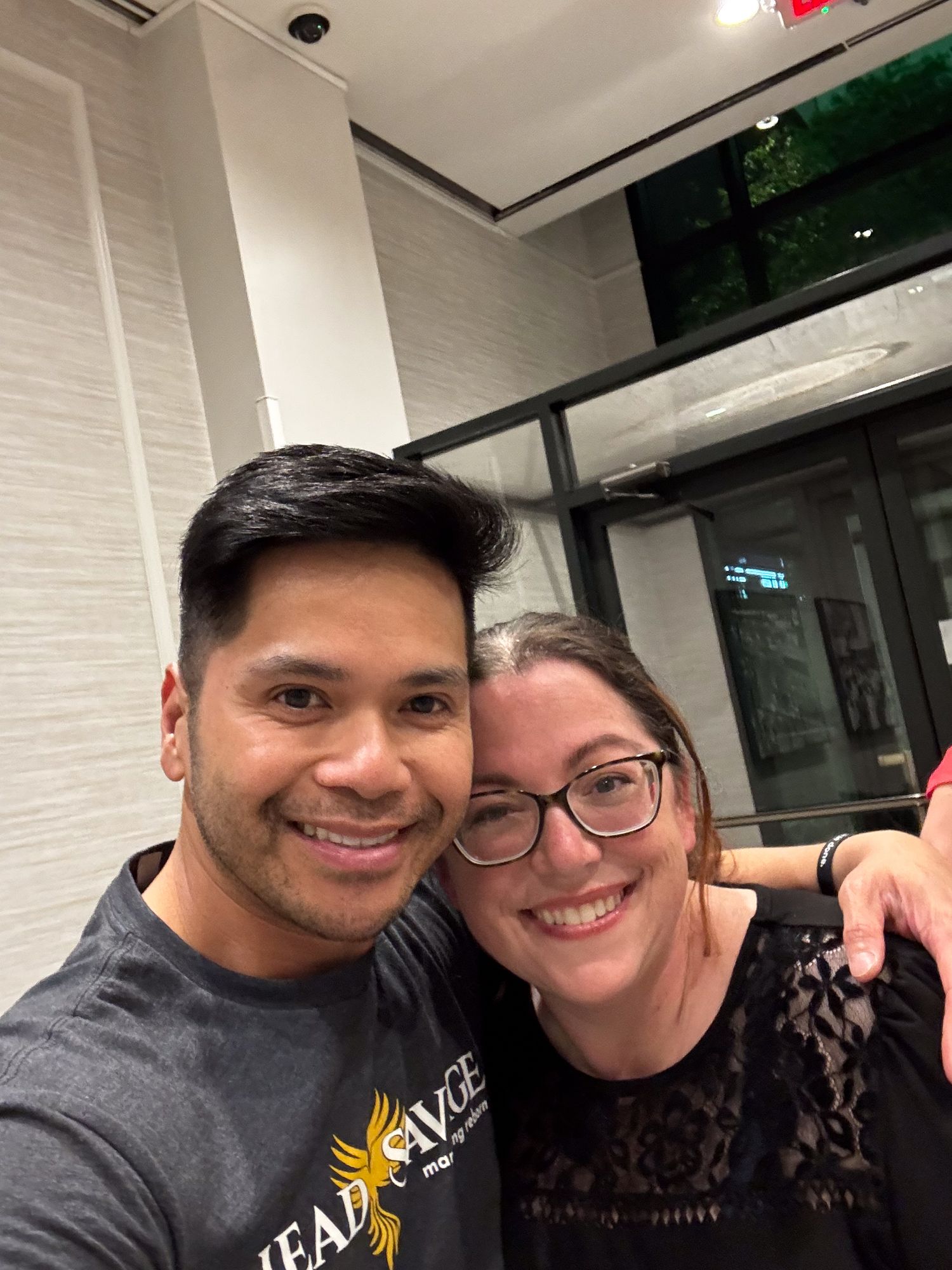 A couple takes a selfie together in what appears to be a restaurant or casual dining space.