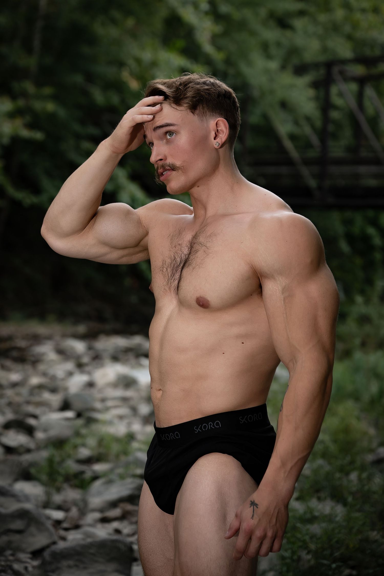 Outdoor portrait series showcasing athletic physique against rocky natural backdrop.