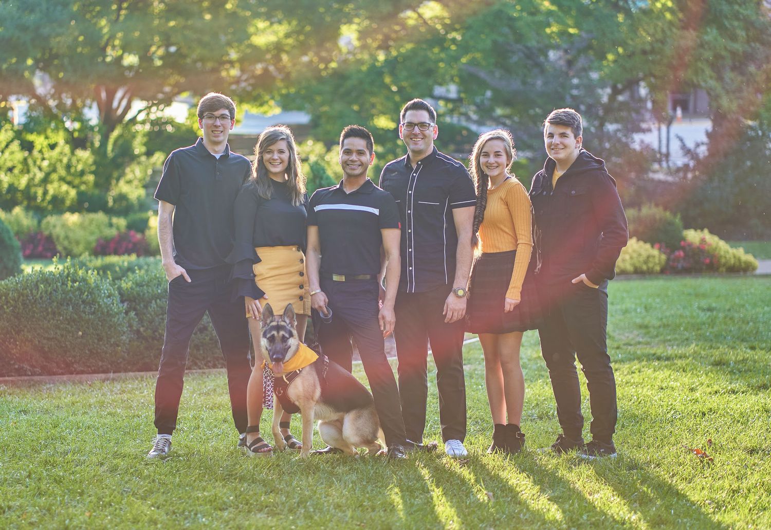 Family group photo session in a sunny park during golden hour.